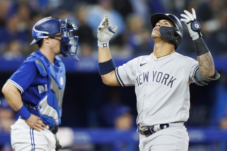 New York Yankees second baseman Gleyber Torres, right, puts his hands in the air and looks to the sky as he crosses home plate in front of Toronto Blue Jays catcher Tyler Heineman, left, after hitting a two-run home run on Monday, May 2, 2022, in Toronto.