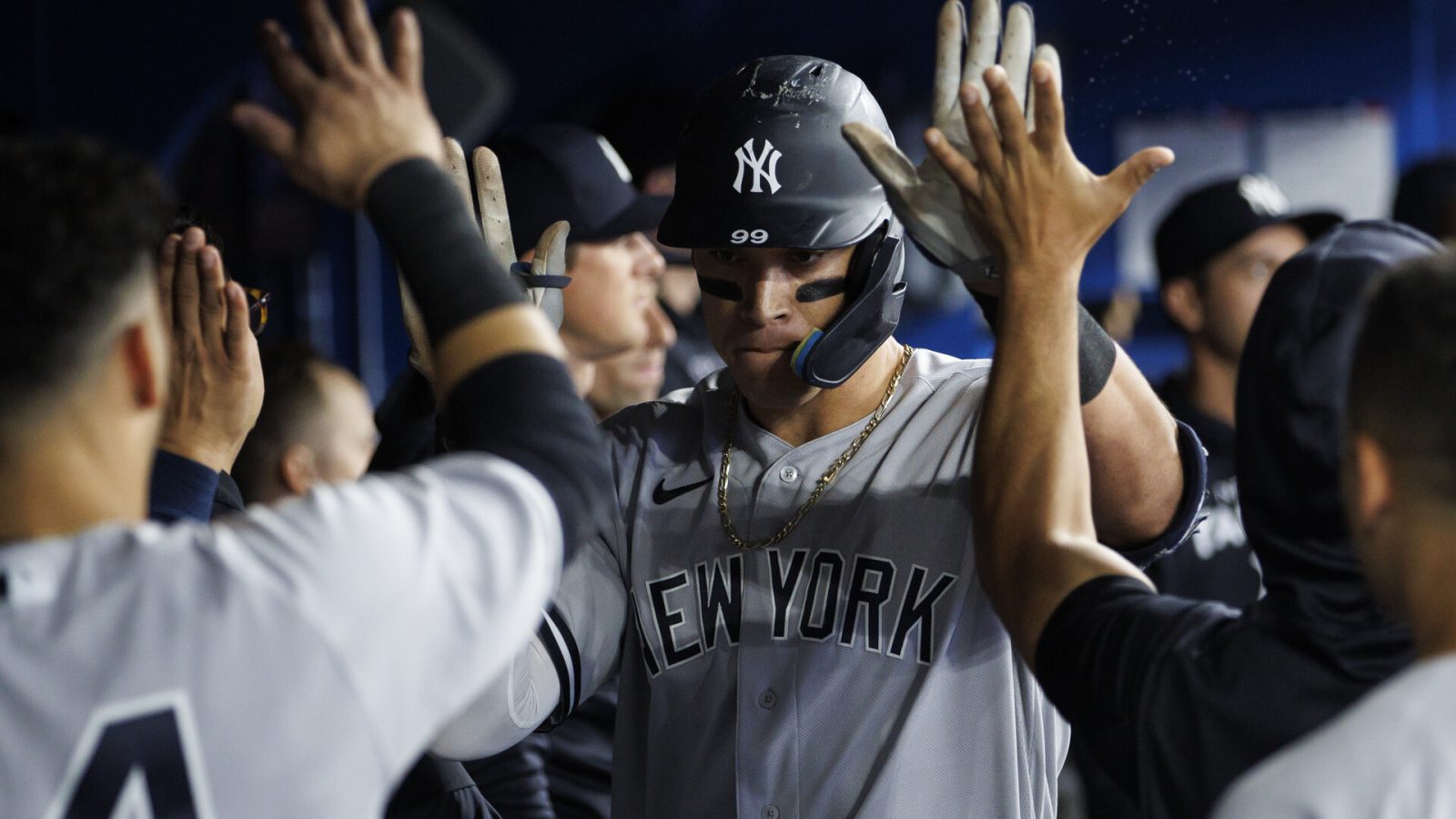 New York Yankees outfielder Aaron Judge, center, accepts congratulations from teammates in the dugout after hitting a home run against the Toronto Blue Jays on Tuesday, May 3, 2022, in Toronto.