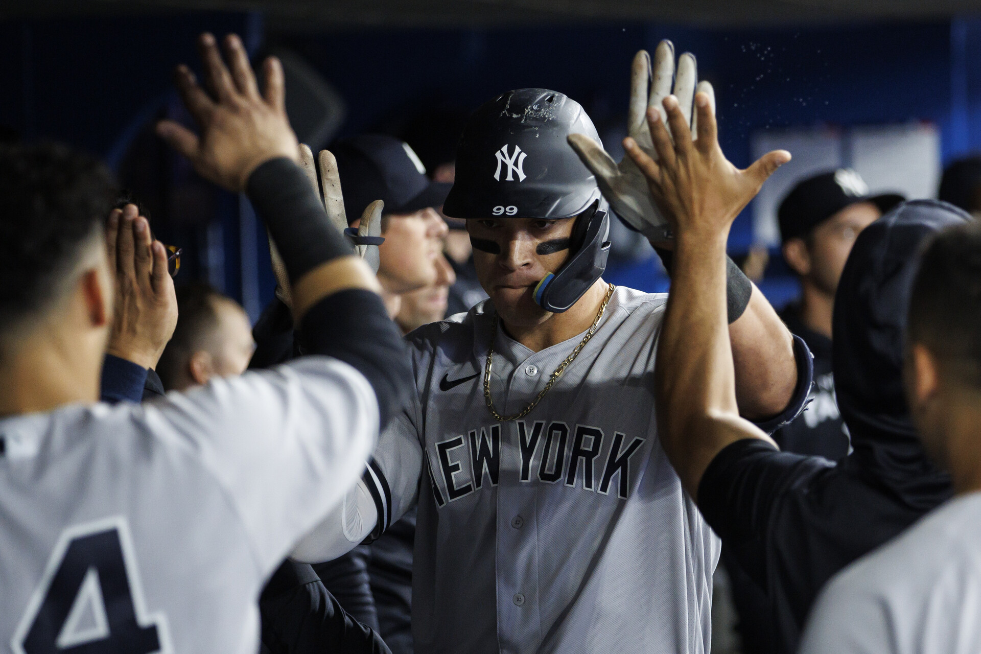 New York Yankees outfielder Aaron Judge, center, accepts congratulations from teammates in the dugout after hitting a home run against the Toronto Blue Jays on Tuesday, May 3, 2022, in Toronto.