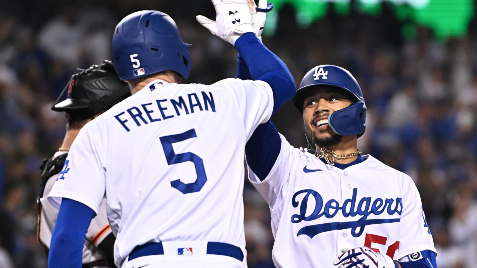 Los Angeles Dodgers right fielder Mookie Betts, right, gives a high-five to first baseman Freddie Freeman, left, with back to camera, after Betts hit a home run Wednesday, May 4, 2022, in Los Angeles.