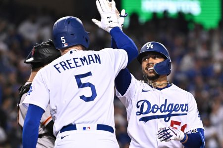 Los Angeles Dodgers right fielder Mookie Betts, right, gives a high-five to first baseman Freddie Freeman, left, with back to camera, after Betts hit a home run Wednesday, May 4, 2022, in Los Angeles.