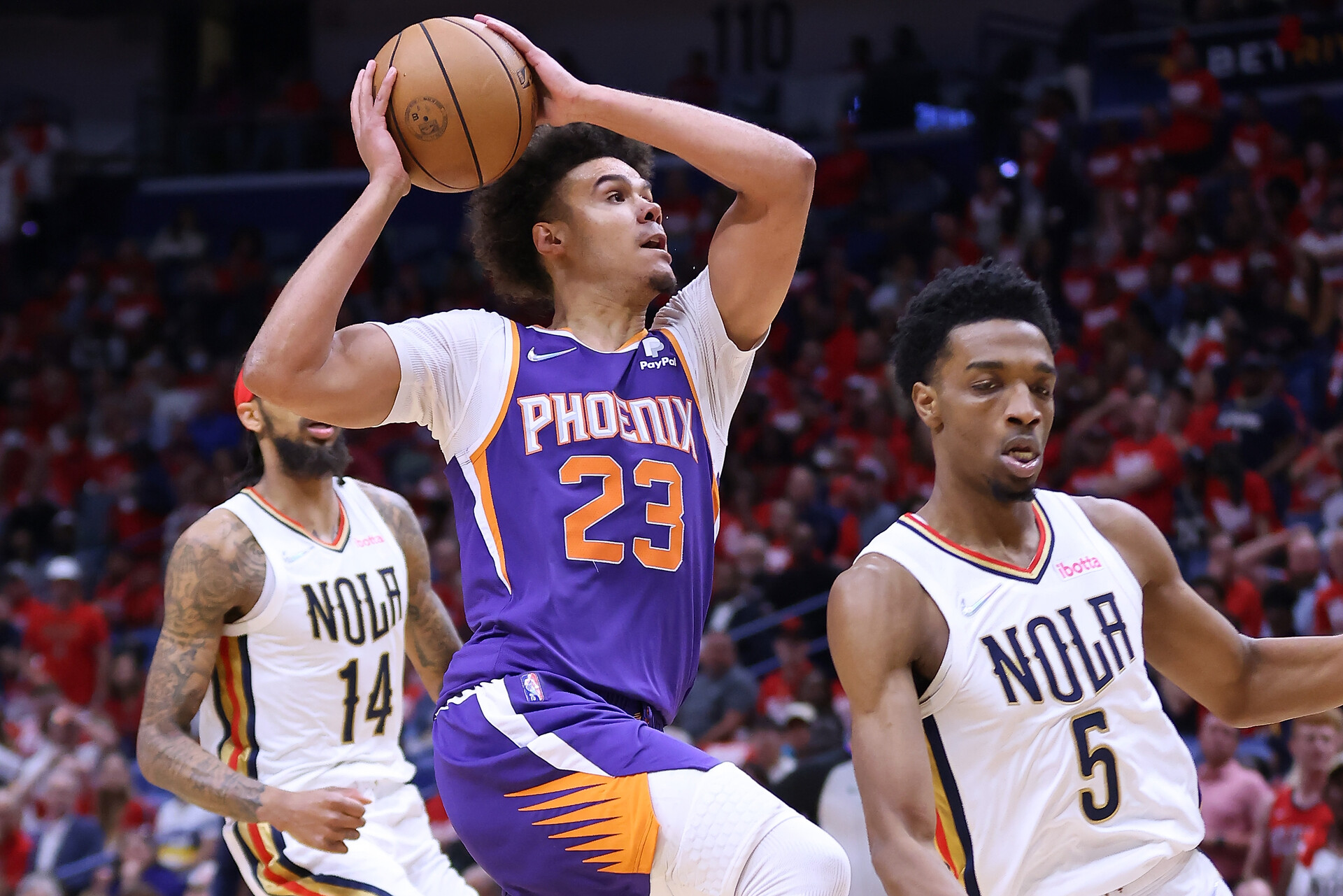 Cameron Johnson (front, left) of the Phoenix Suns drives against Herbert Jones (right) of the New Orleans Pelicans during the second half of Game Four of the Western Conference First Round at the Smoothie King Center on April 24, 2022 in New Orleans, Louisiana.