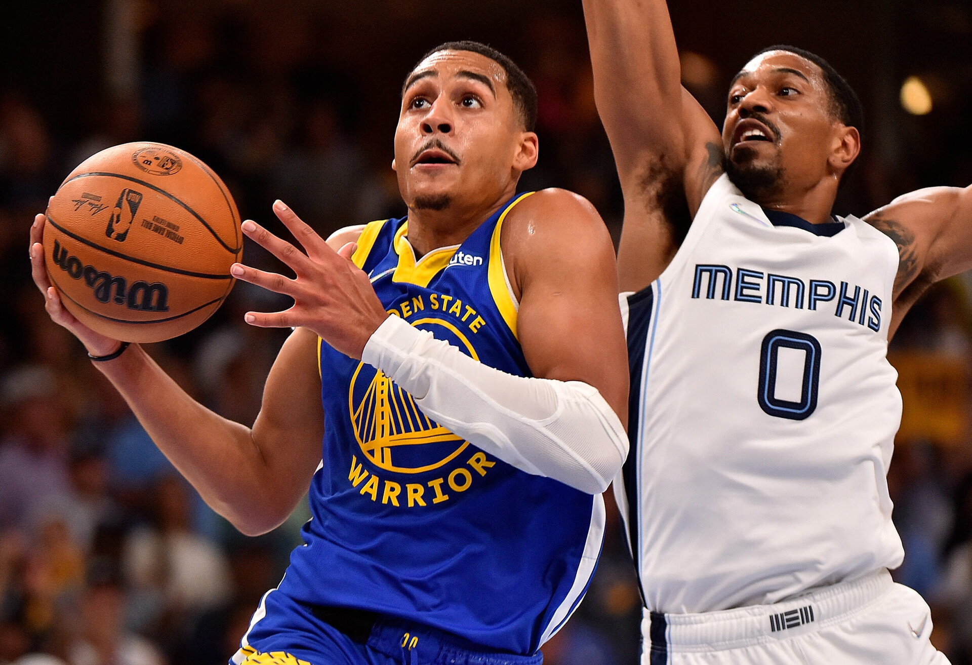 Golden State Warriors guard Jordan Poole, left, drives with the ball in his right hand against Memphis Grizzlies guard De'Anthony Melton, right, on Sunday, May 1, 2022, in Memphis, Tenn.