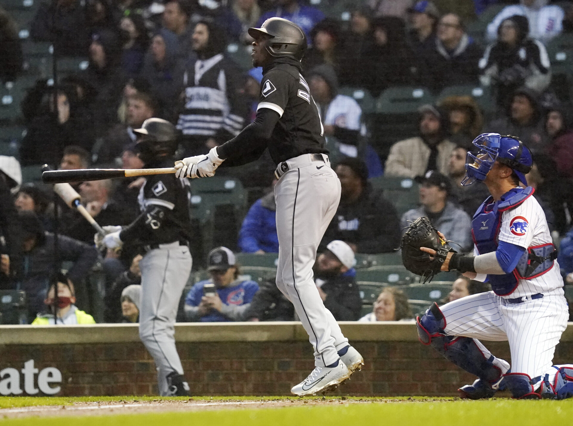 Chicago White Sox shortstop Tim Anderson, center, watches the flight of his home run as Chicago Cubs catcher Yan Gomes, right, looks on Tuesday, May 3, 2022, in Chicago.