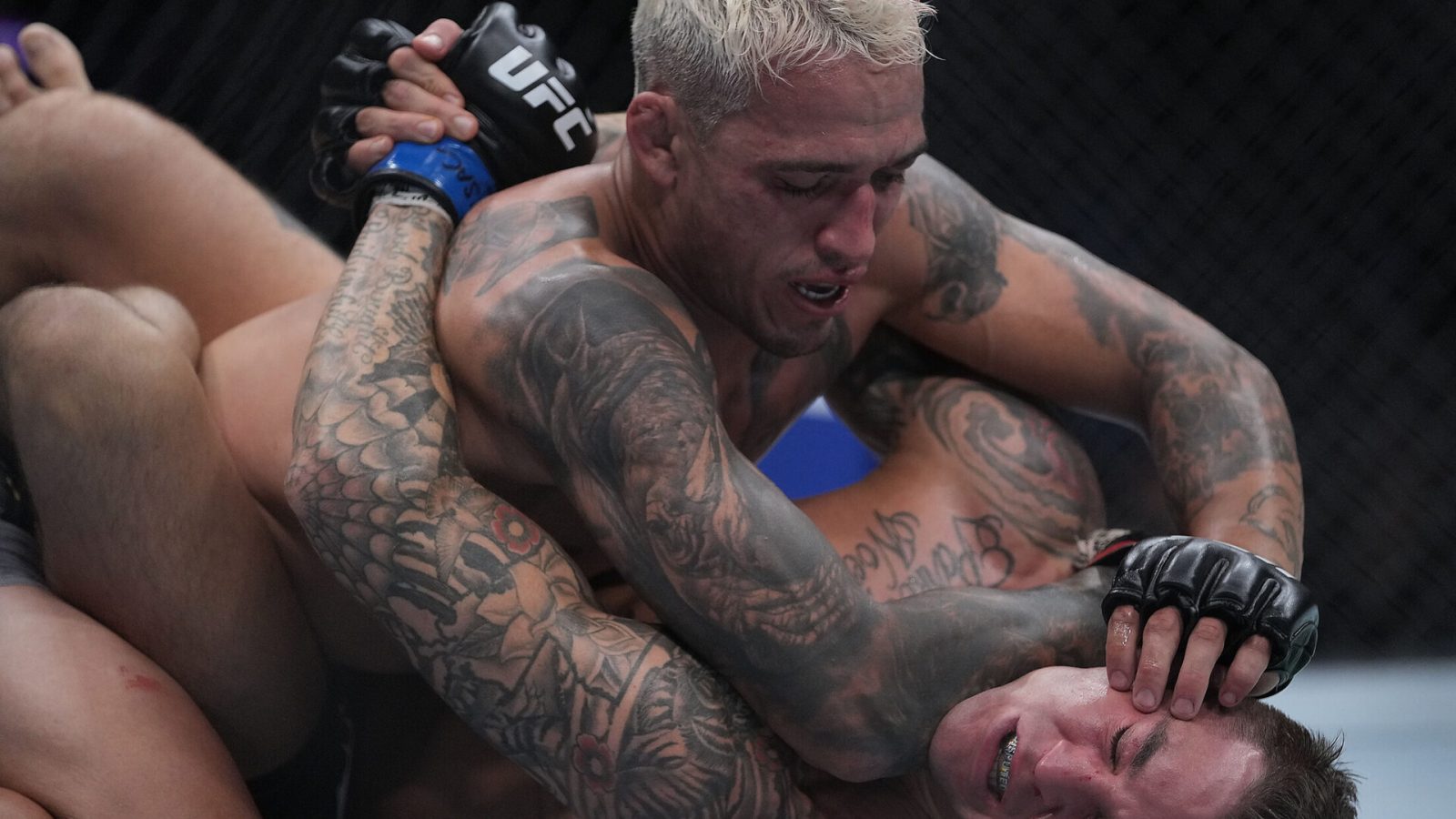 Charles Oliveira, top, pins Dustin Poirier, bottom, to the mat during UFC 269 at T-Mobile Arena in Las Vegas.