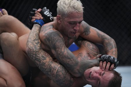 Charles Oliveira, top, pins Dustin Poirier, bottom, to the mat during UFC 269 at T-Mobile Arena in Las Vegas.