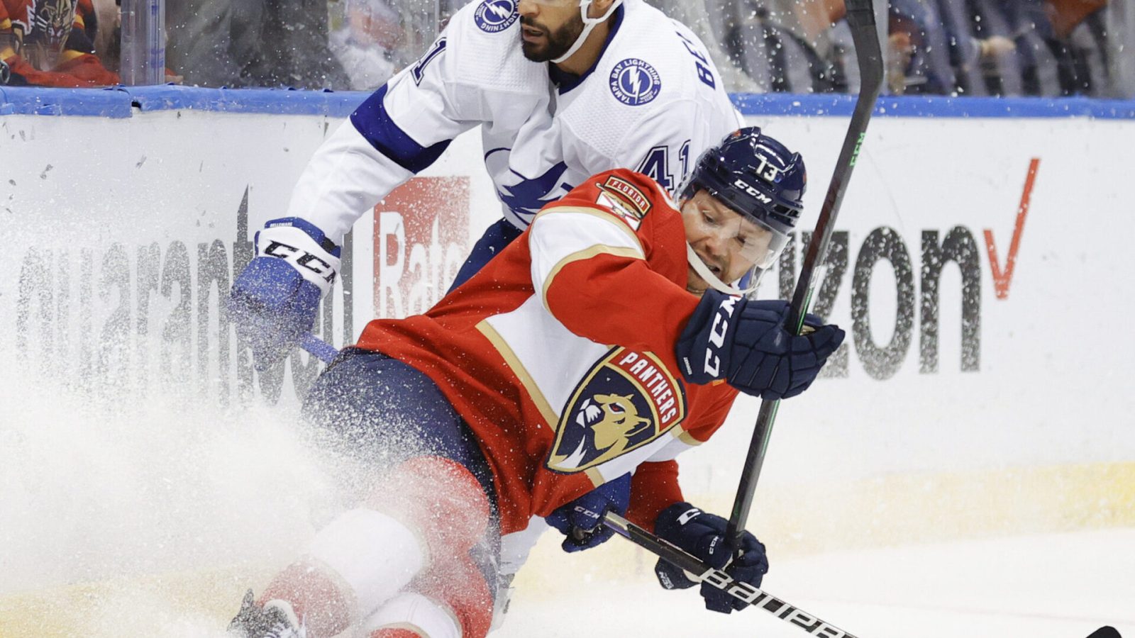 Florida Panthers center Sam Reinhart (right) loses his footing and is about to fall to the ice while trying to keep and Tampa Bay Lightning left wing Pierre-Edouard Bellemare (left) away from the puck along the boards