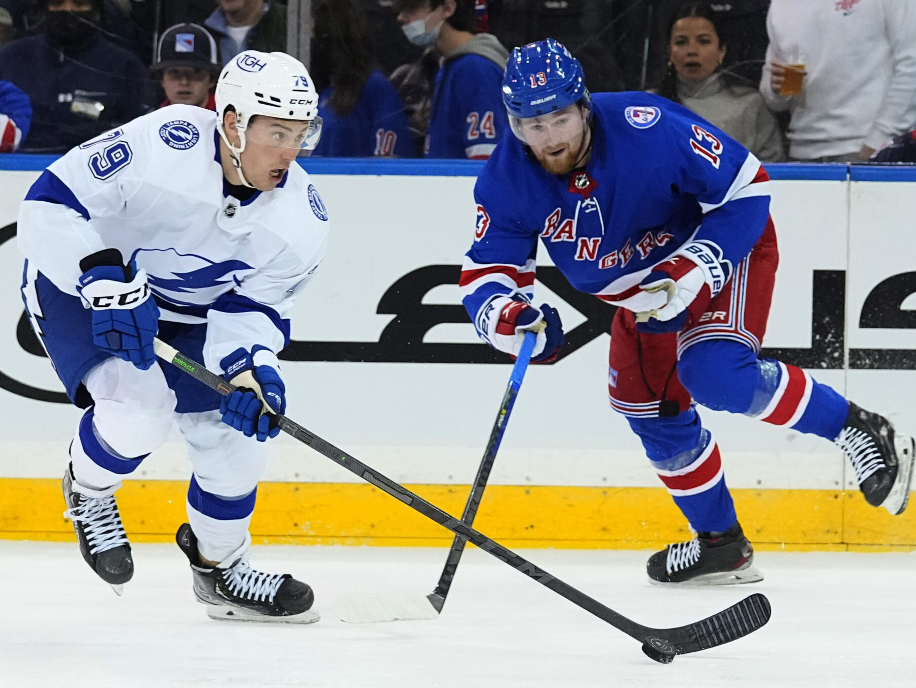 Tampa Bay Lightning left wing Ross Colton (left) controls the puck on his stick as New York Rangers left wing Alexis Lafreniere (right) defends