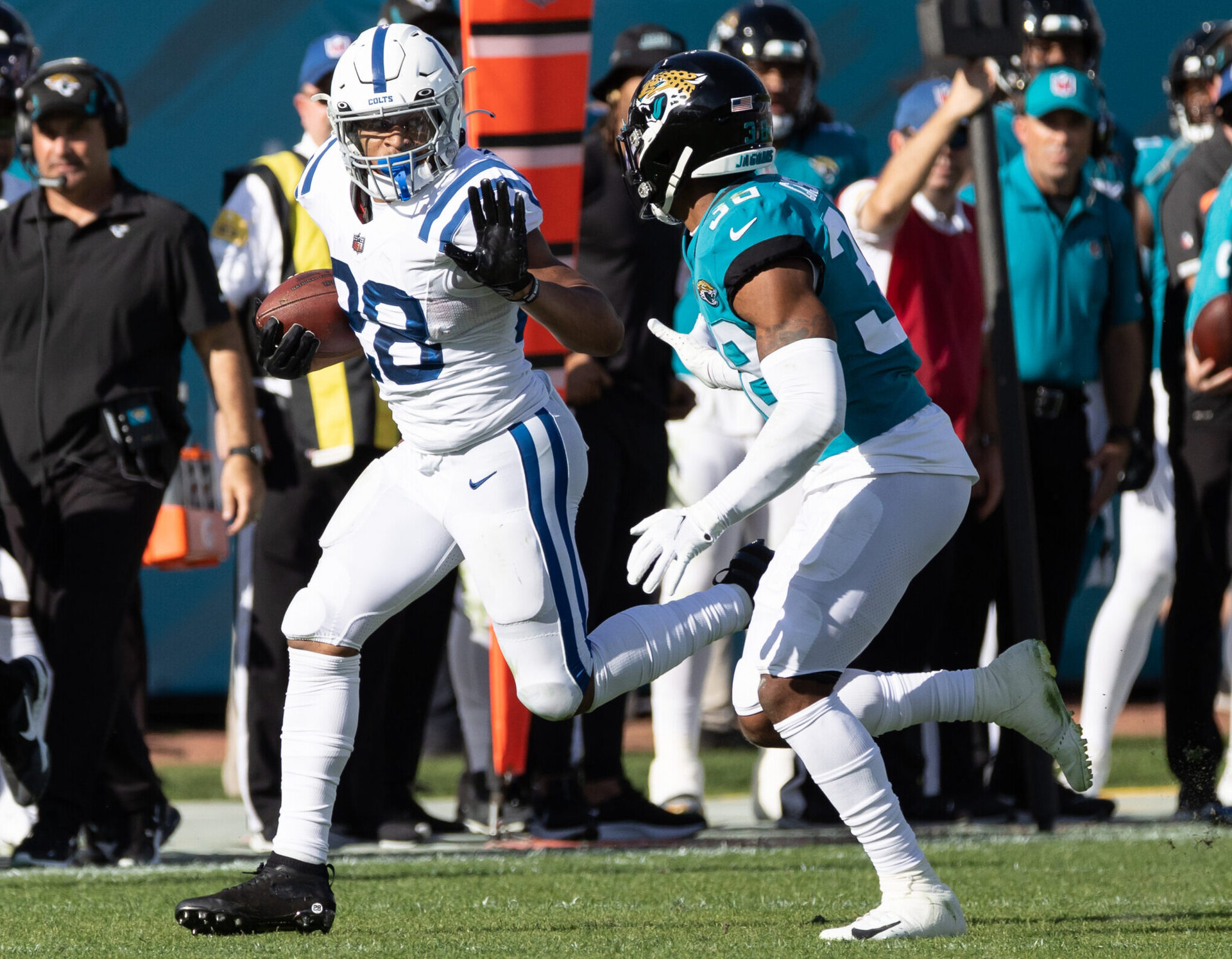 Indianapolis Colts running back Jonathan Taylor, left, prepares to stiff-arm Jacksonville Jaguars safety Andre Cisco, right, on Jan. 9, 2022, in Jacksonville, Fla.