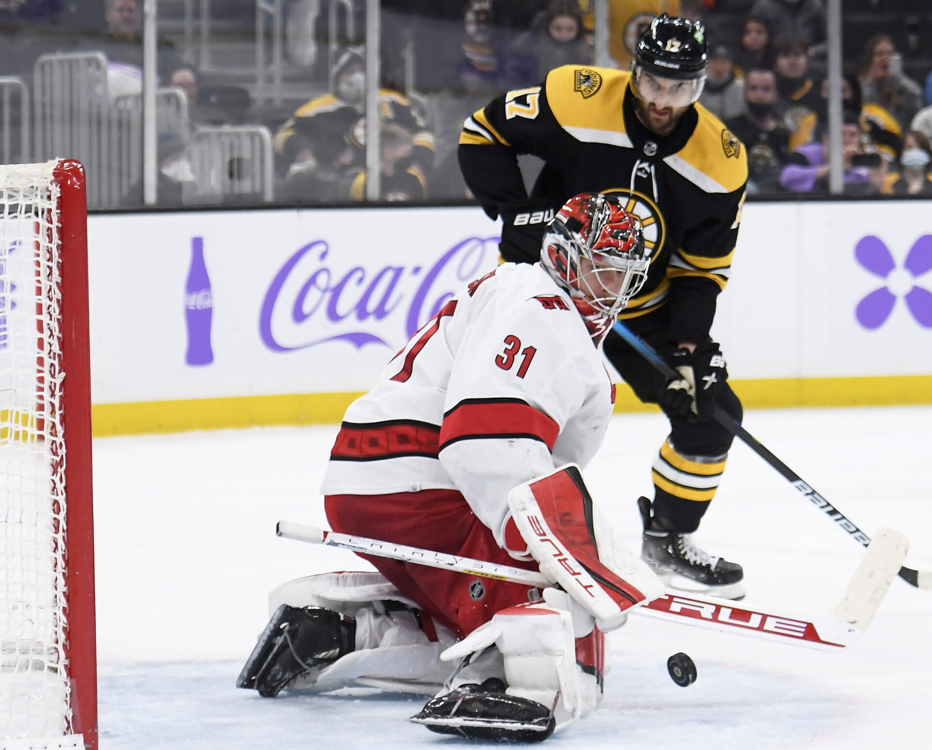Carolina Hurricanes goaltender Frederik Andersen makes a save of the puck while Boston Bruins left wing Nic Foligno looks to snag the rebound