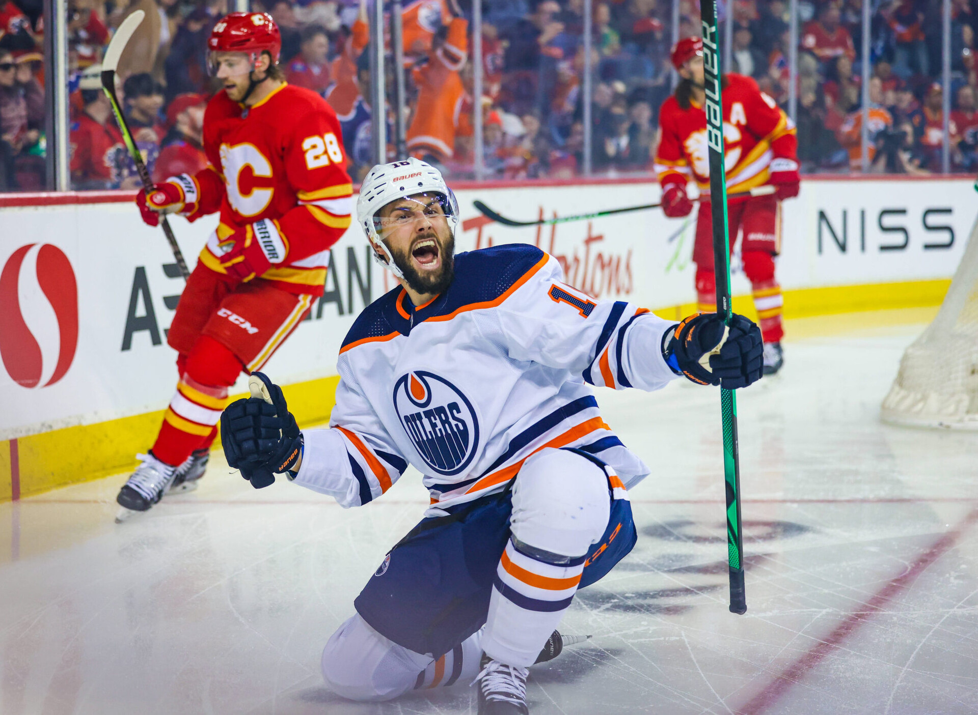 Edmonton Oilers center Derick Brassard droops to his knees, pumps his fist and shouts as he celebrates his goal against the Calgary Flames