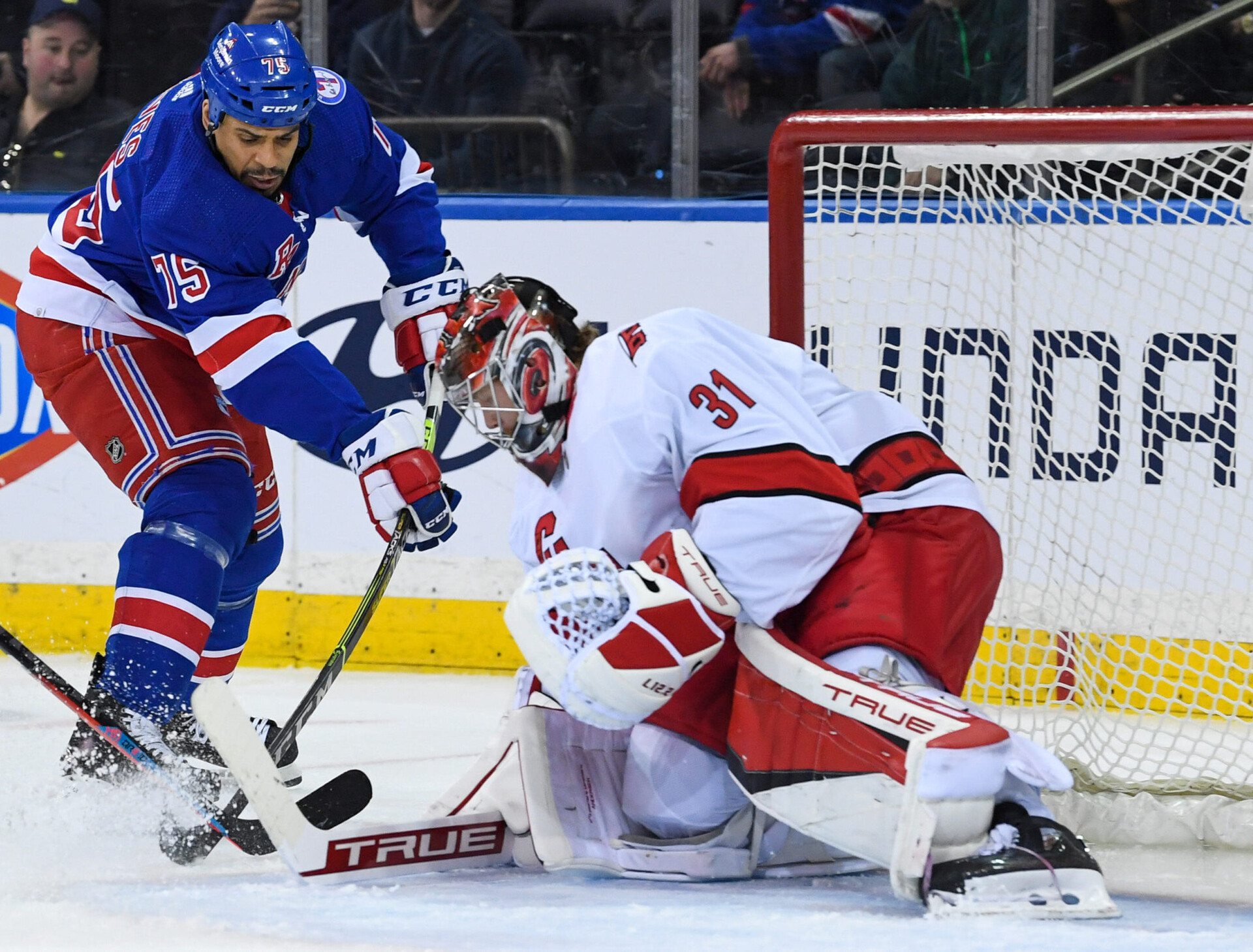 Carolina Hurricanes goaltender Frederik Andersen (left) stops the shot by New York Rangers right wing Ryan Reaves (right)