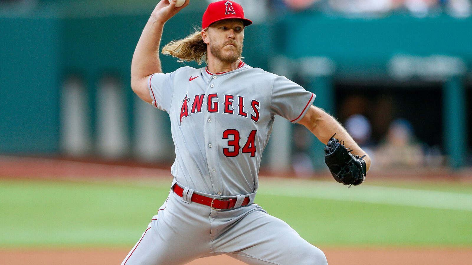 Los Angeles Angels right-handed starting pitcher Noah Syndergaard grips the baseball in his right hand and grimaces as he begins to deliver a pitch against the Texas Rangers