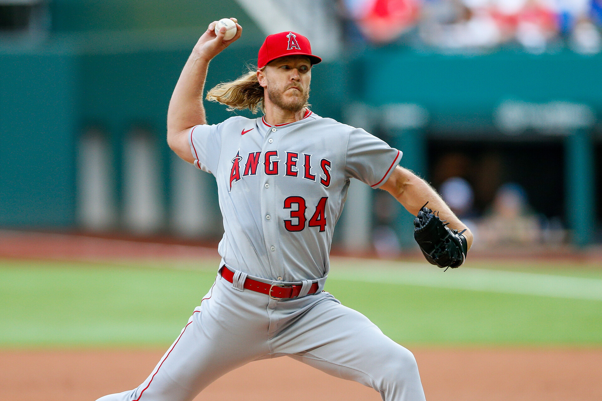 Los Angeles Angels right-handed starting pitcher Noah Syndergaard grips the baseball in his right hand and grimaces as he begins to deliver a pitch against the Texas Rangers