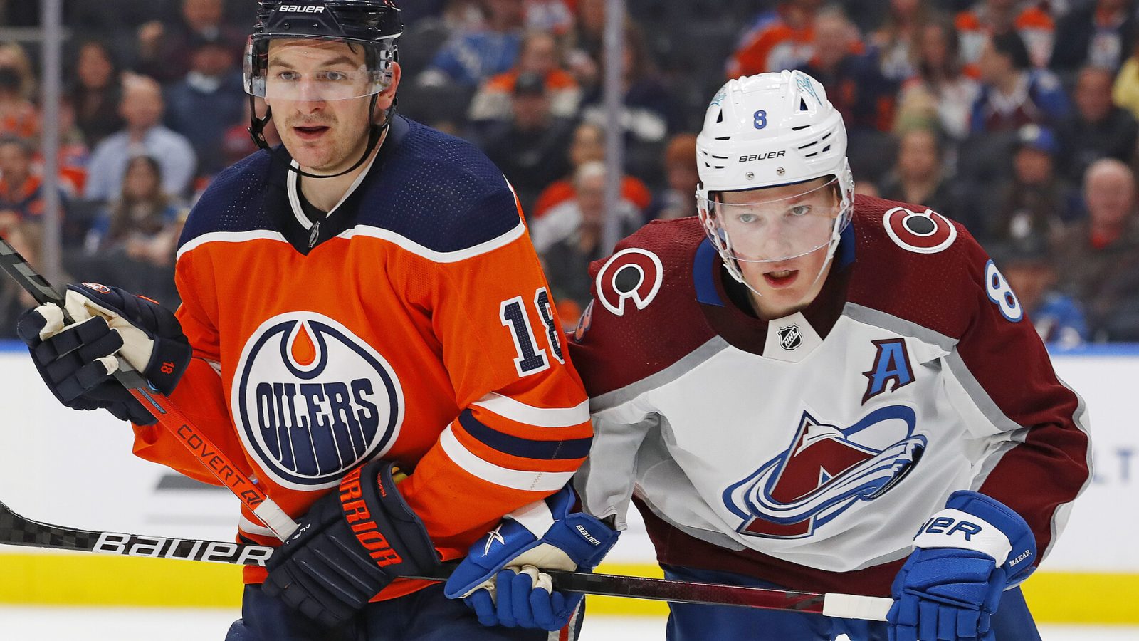 Edmonton Oilers forward Zach Hyman (left) and Colorado Avalanche defensemen Cale Makar (right) keep an eye on the puck and pursue the play