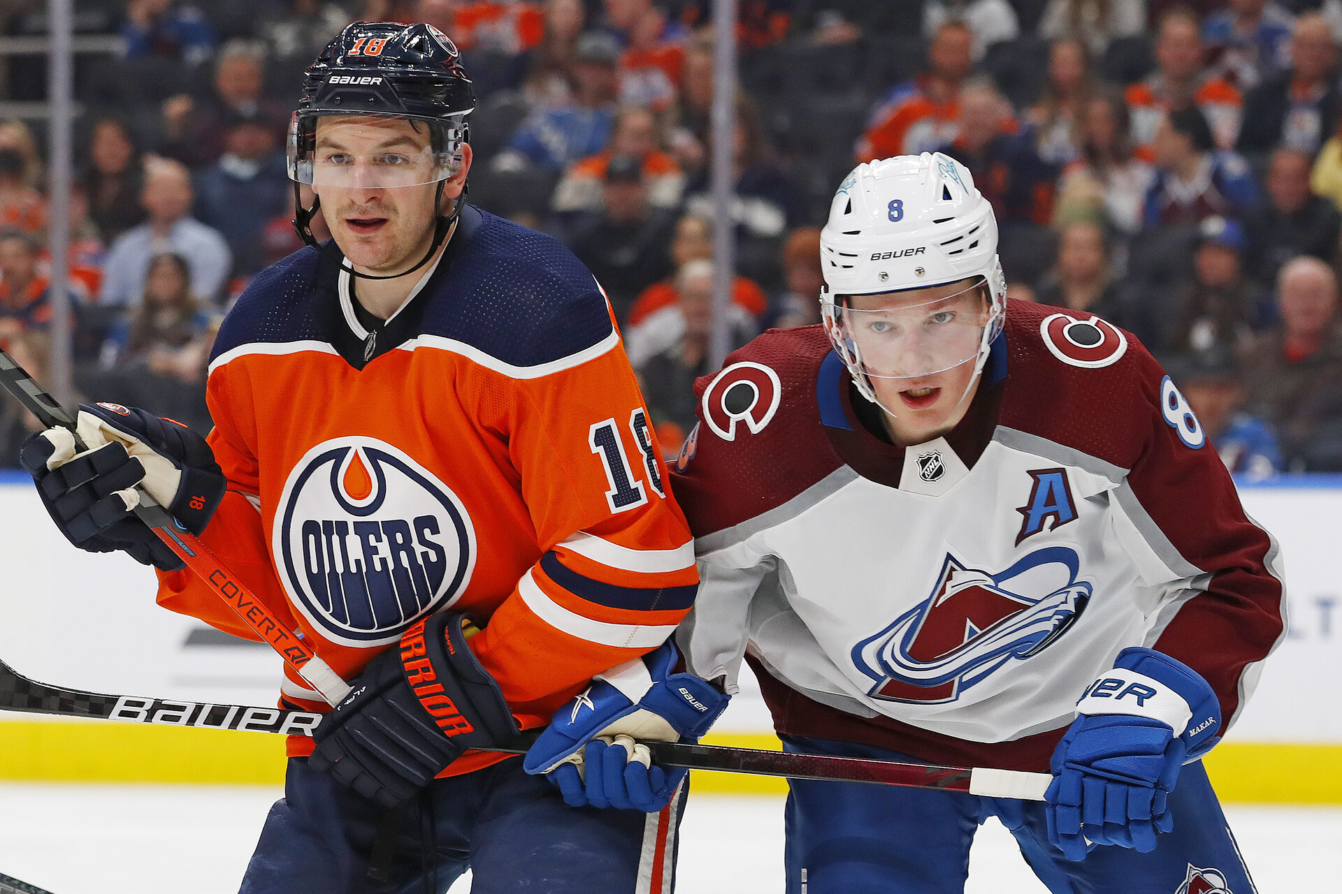 Edmonton Oilers forward Zach Hyman (left) and Colorado Avalanche defensemen Cale Makar (right) keep an eye on the puck and pursue the play
