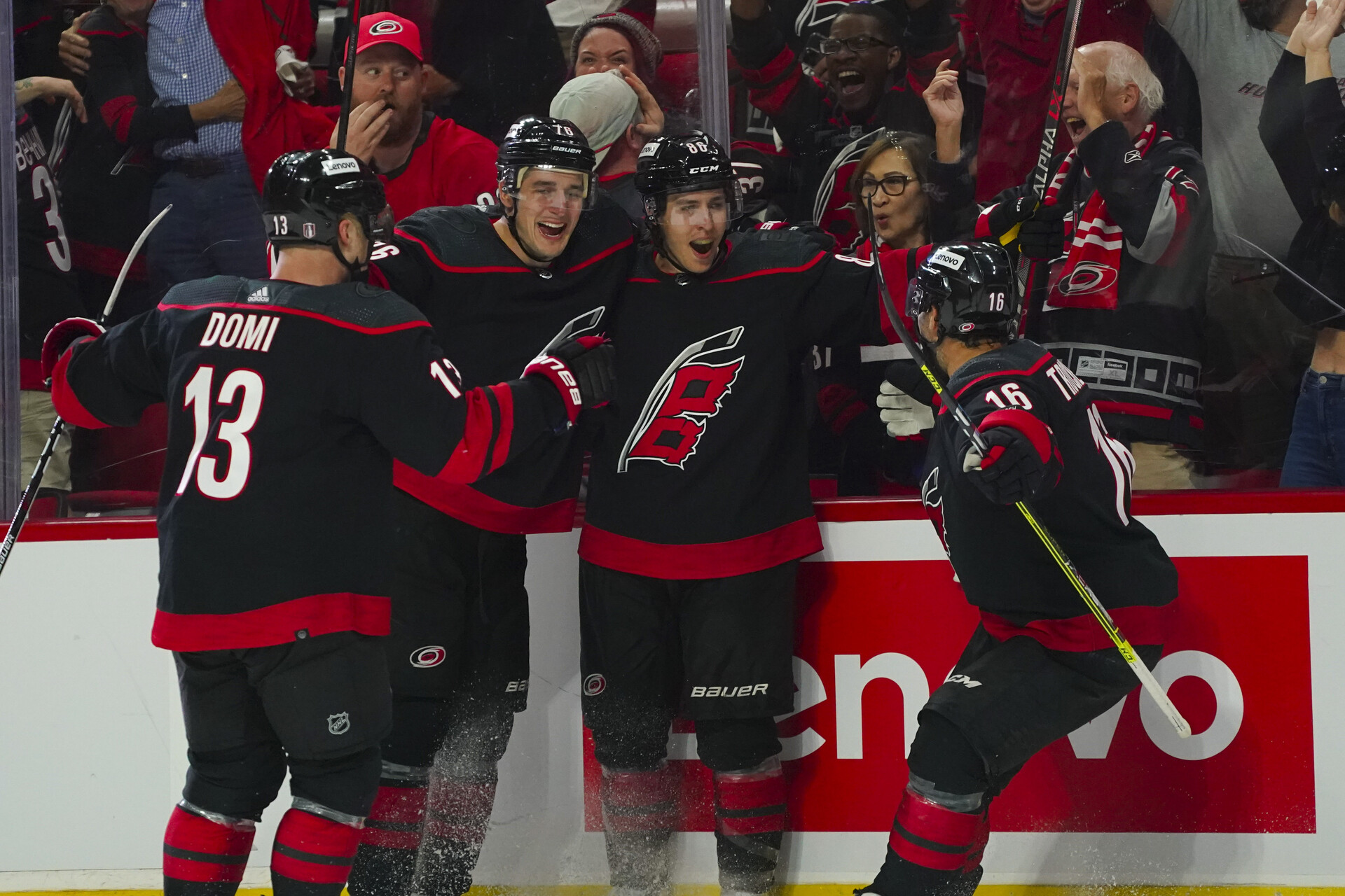 Carolina Hurricanes left wing Teuvo Teravainen (86) is congratulated by left wing Jordan Martinook (48) defenseman Brady Skjei (76) and center Max Domi (13) after this goal against the Boston Bruins during the third period in game one of the first round of the 2022 Stanley Cup Playoffs at PNC Arena.