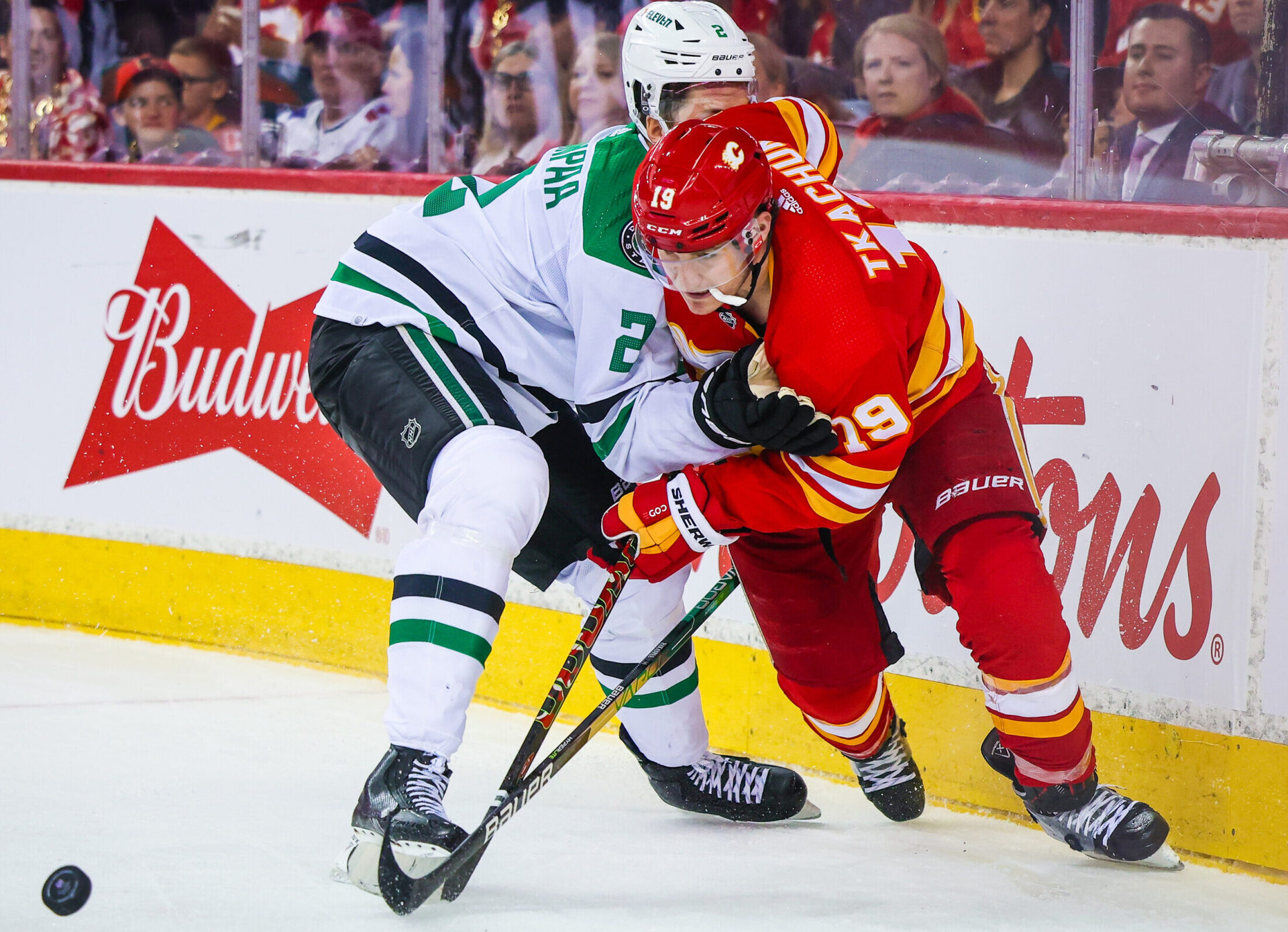 Calgary Flames left wing Matthew Tkachuk (right) and Dallas Stars defenseman Jani Hakanpaa (left) battle for the puck during a 2022 Stanley Cup Playoff game