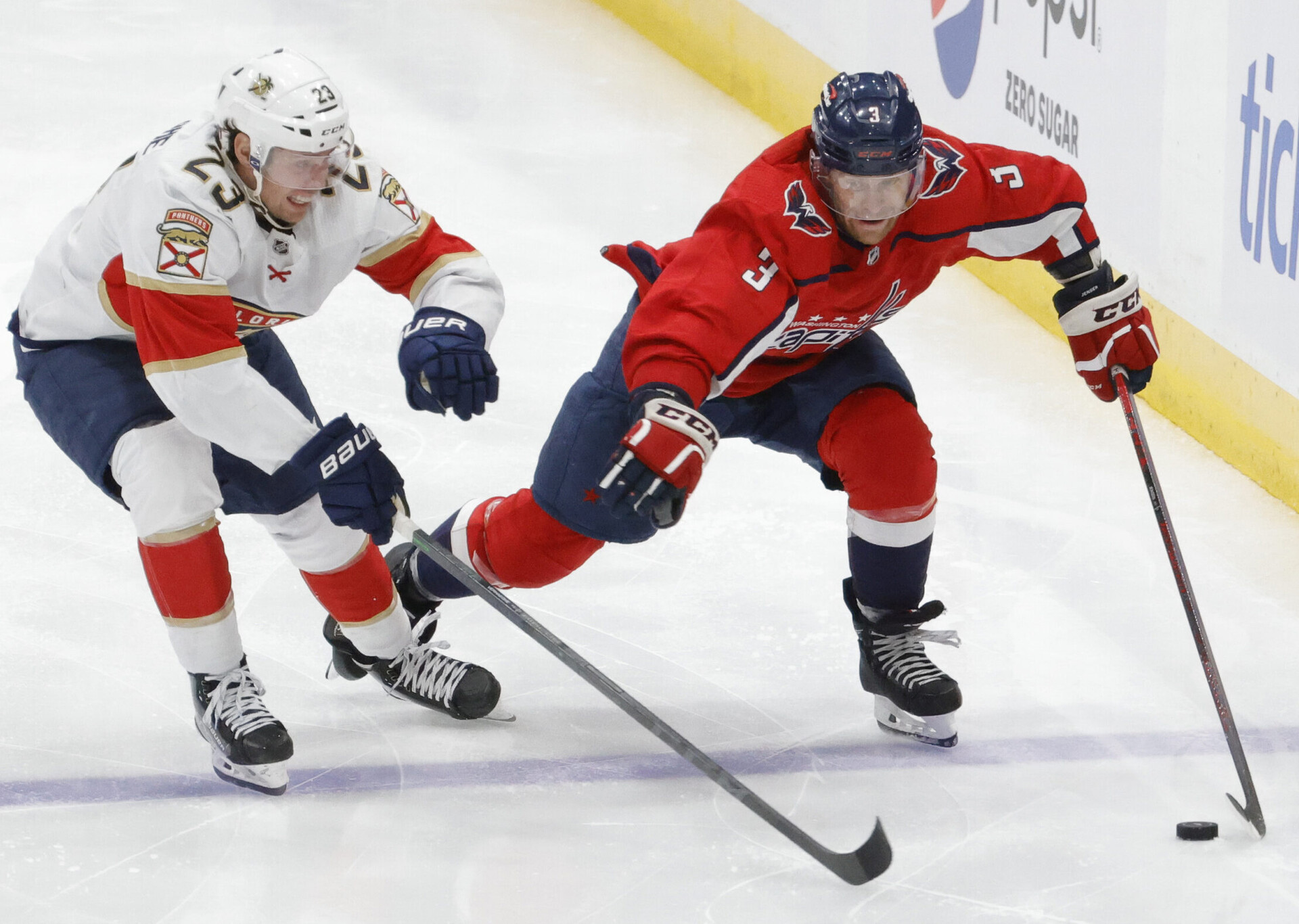 Washington Capitals defenseman Nick Jensen (right) skates with the puck past Florida Panthers center Carter Verhaeghe (left) during a 2022 Stanley Cup Playoffs game