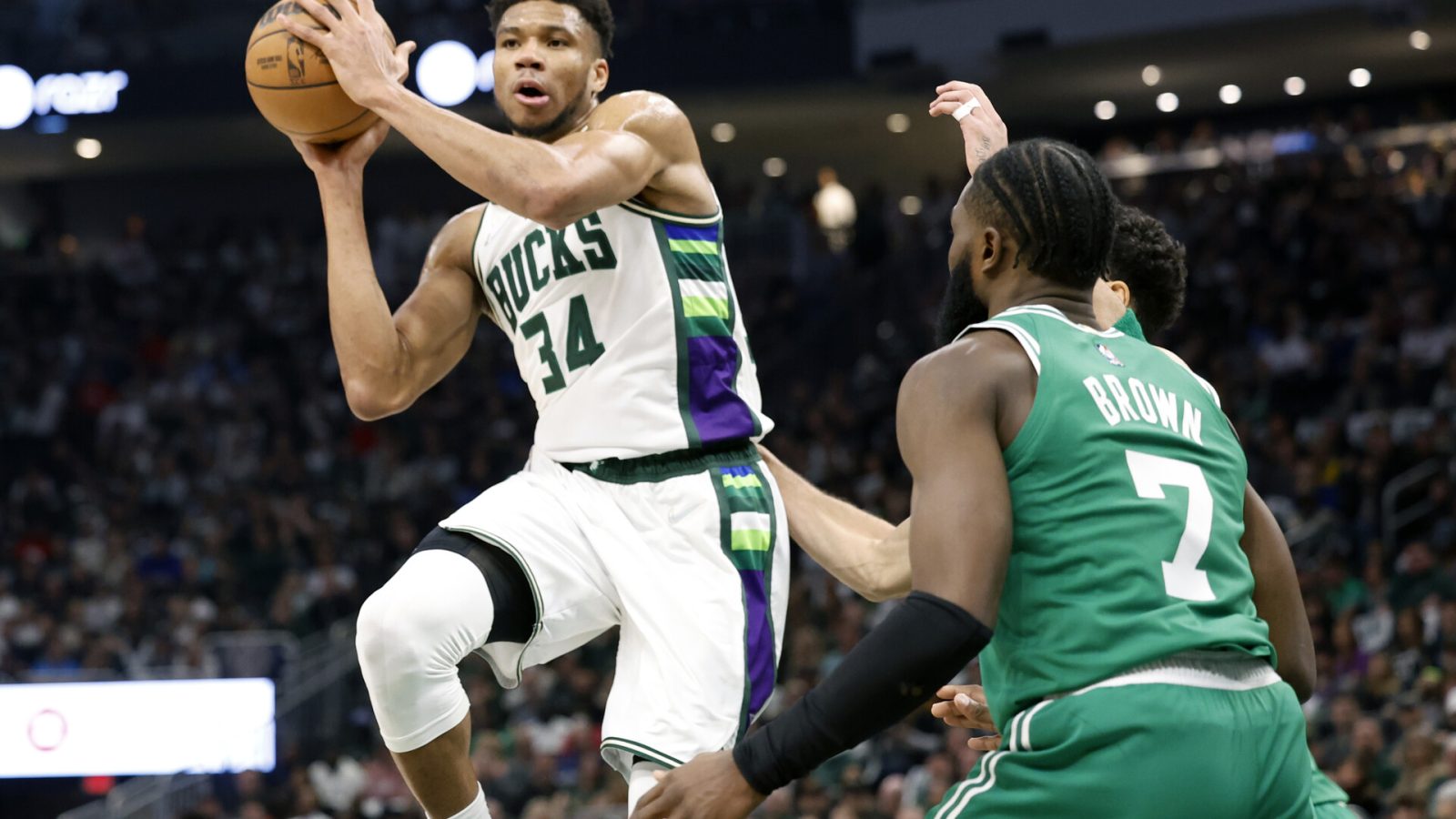 Milwaukee Bucks forward Giannis Antetokounmpo (left) passes the ball under pressure form Boston Celtics guard Jaylen Brown (right) during the second quarter during game three of the second round for the 2022 NBA playoffs at Fiserv Forum.