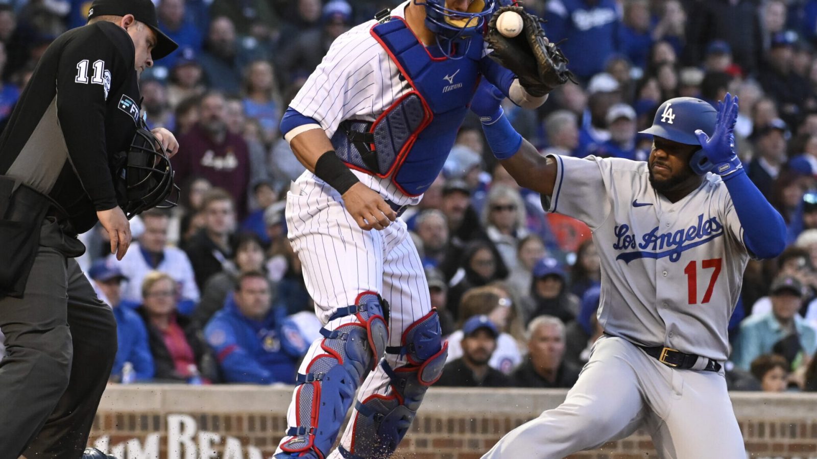 Los Angeles Dodgers second baseman Hanser Alberto (right) slides safely into home plate as Chicago Cubs catcher Yan Gomes (left) catches the baseball