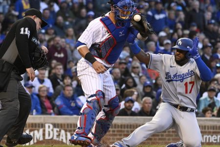 Los Angeles Dodgers second baseman Hanser Alberto (right) slides safely into home plate as Chicago Cubs catcher Yan Gomes (left) catches the baseball