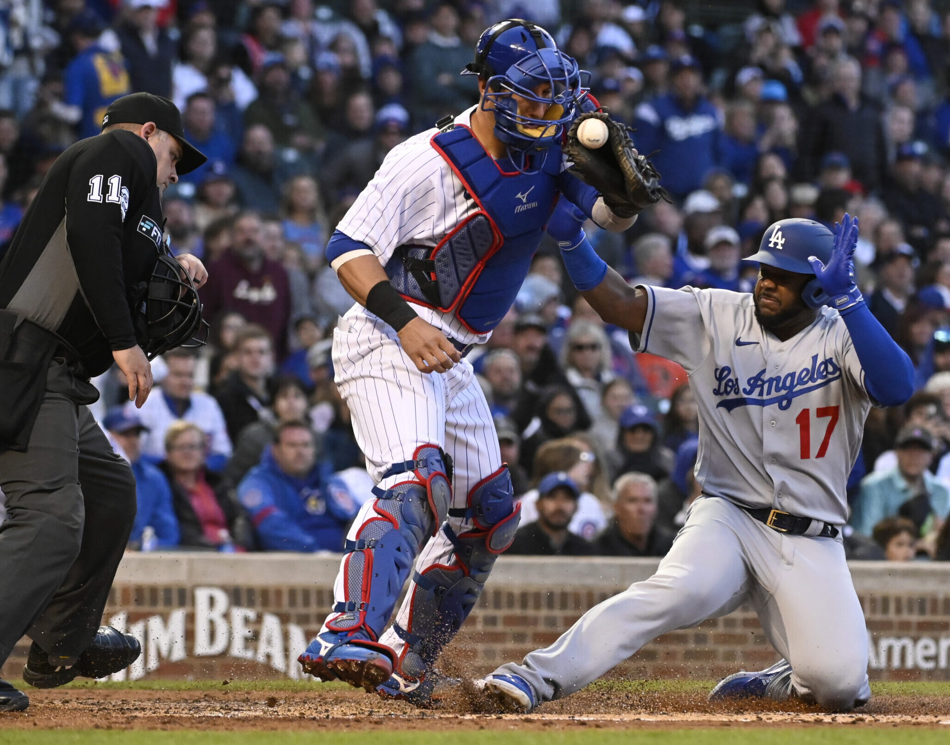 Los Angeles Dodgers second baseman Hanser Alberto (right) slides safely into home plate as Chicago Cubs catcher Yan Gomes (left) catches the baseball