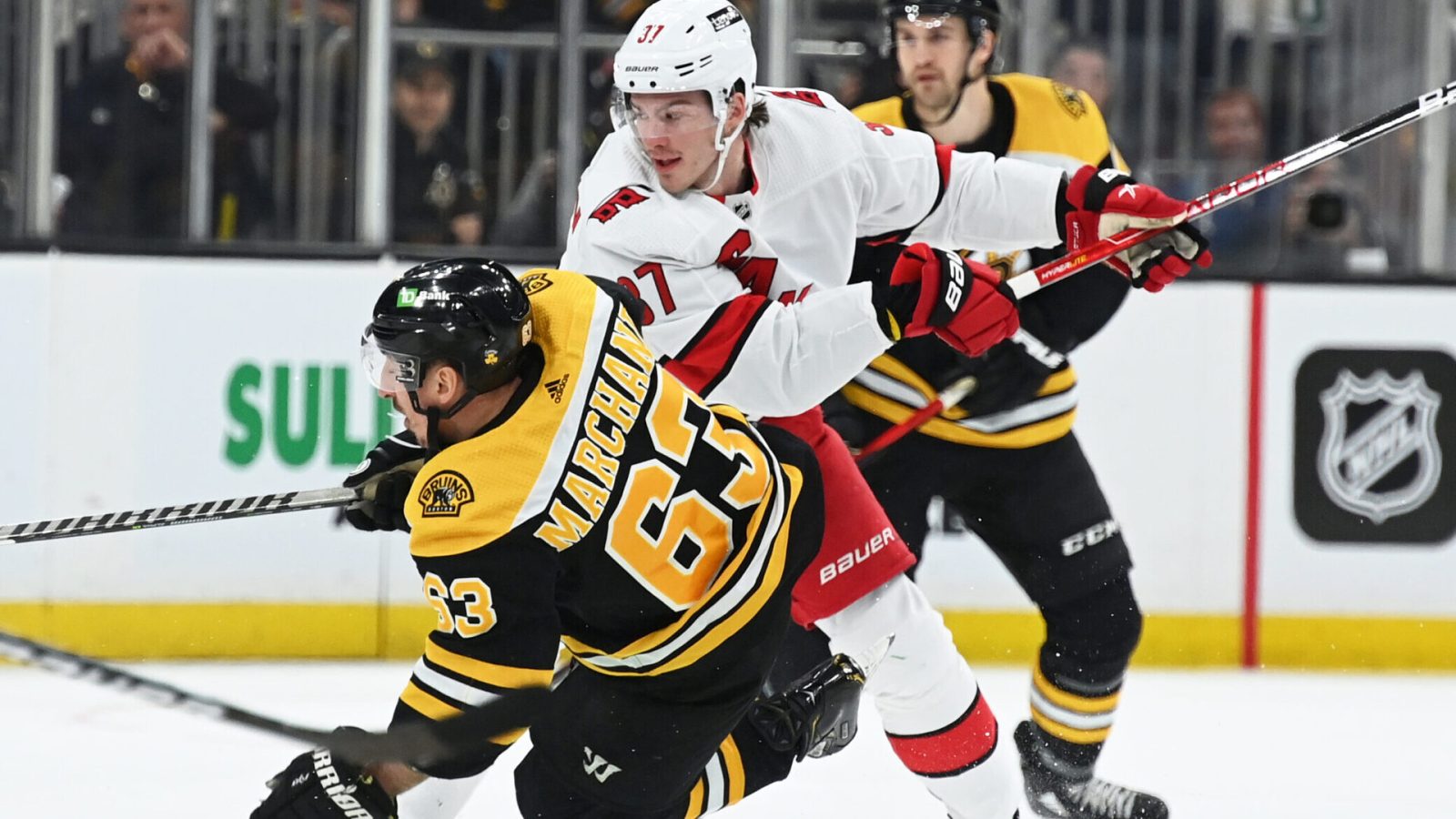 Carolina Hurricanes right wing Andrei Svechnikov (right) checks Boston Bruins left wing Brad Marchand (left) to the ice during a 2022 Stanley Cup Playoffs game