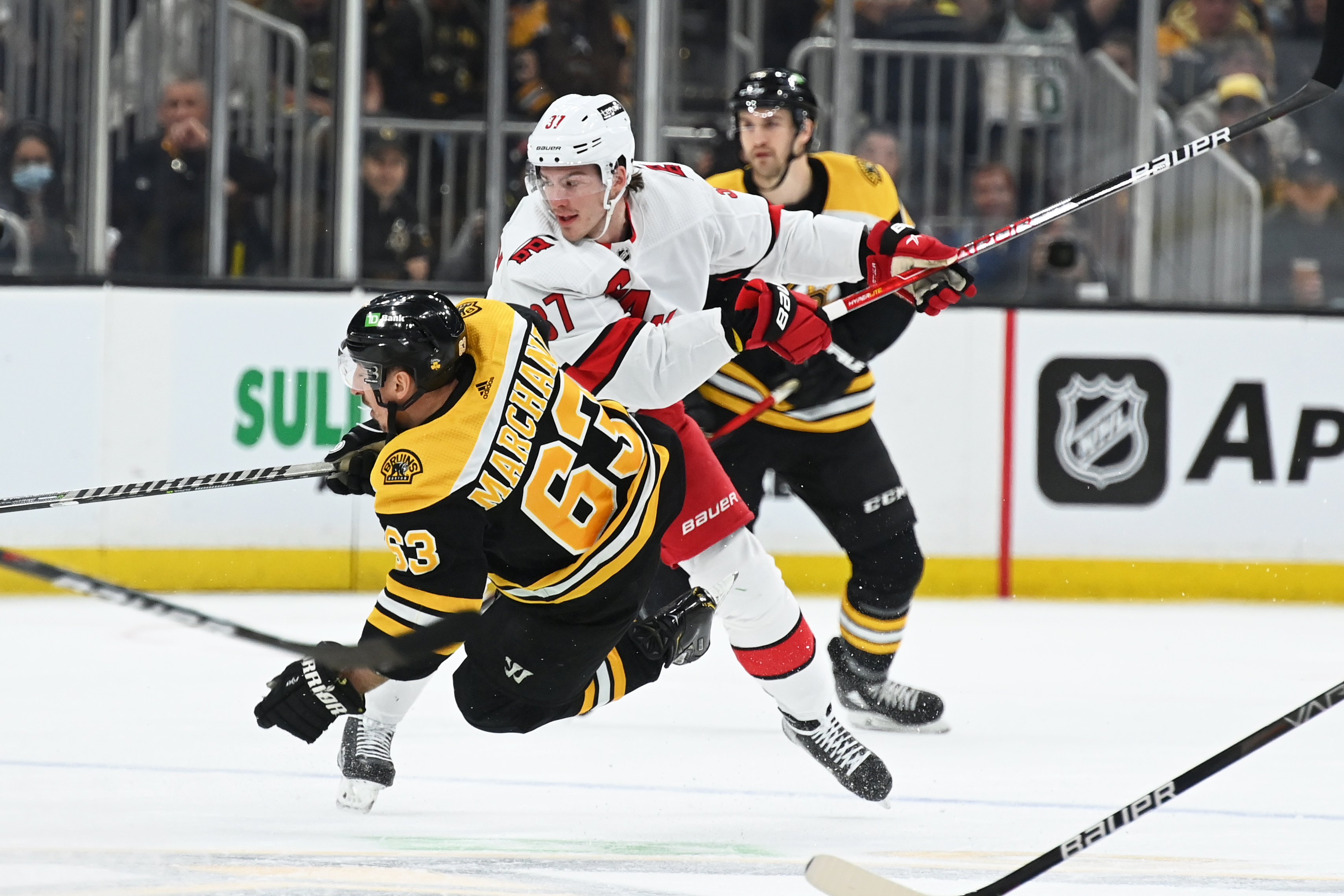 Carolina Hurricanes right wing Andrei Svechnikov (right) checks Boston Bruins left wing Brad Marchand (left) to the ice during a 2022 Stanley Cup Playoffs game