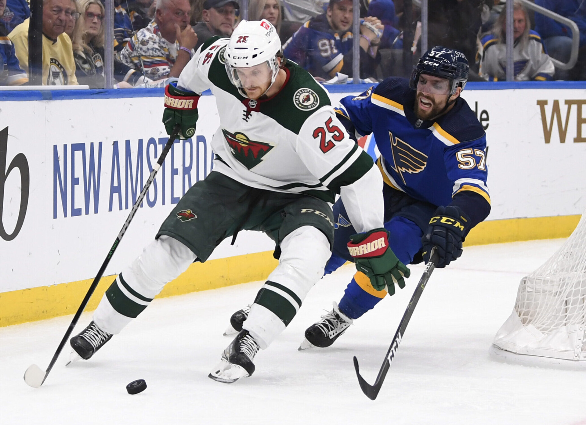St. Louis Blues left wing David Perron (right) pressures Minnesota Wild defenseman Jonas Brodin (left) as Brodin controls the puck with his stick during a 2022 Stanley Cup Playoffs game