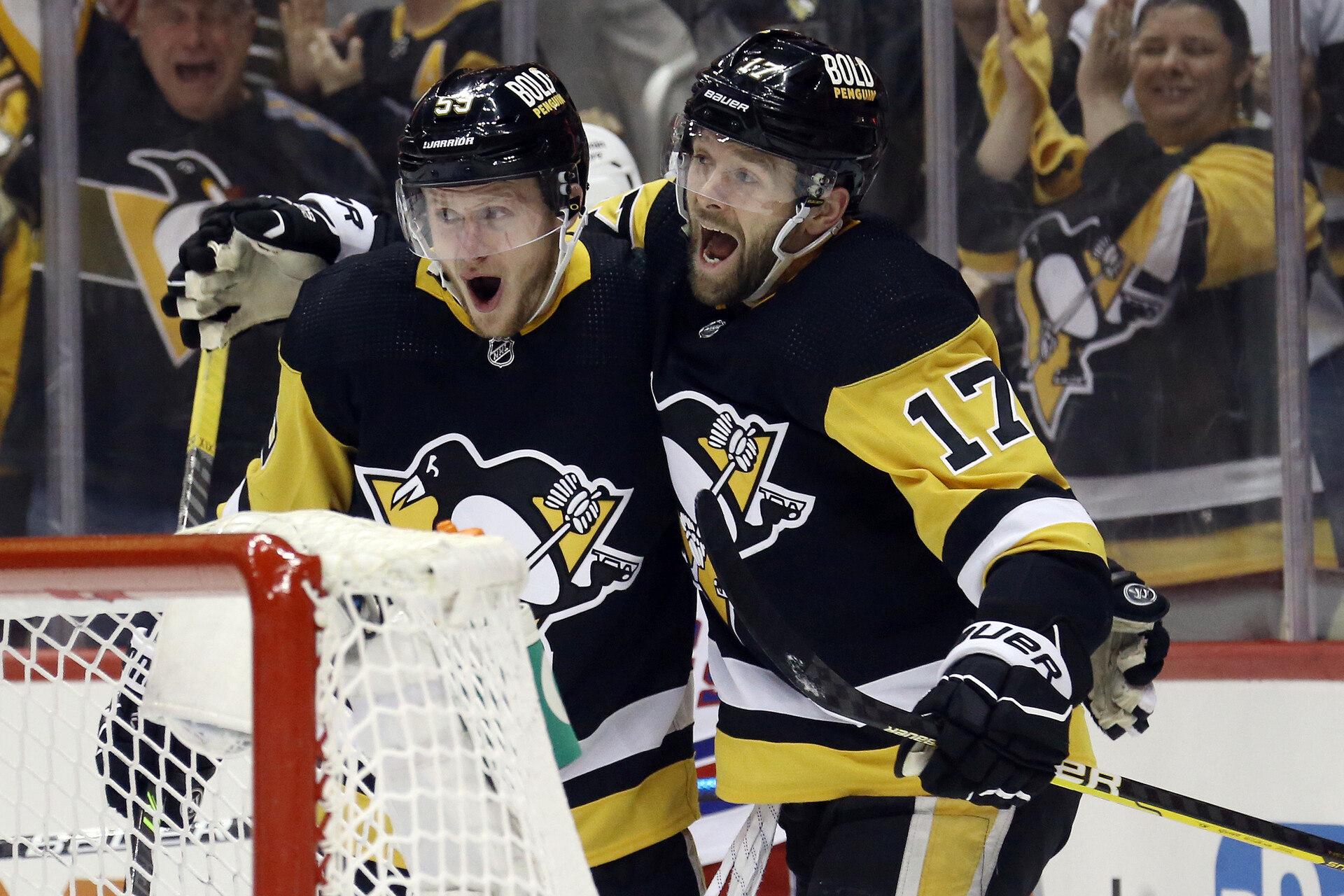 Pittsburgh Penguins left wing Jake Guentzel (left) and right wing Bryan Rust (right) celebrate a goal by Guentzel against the New York Rangers during a 2022 Stanley Cup Playoffs game
