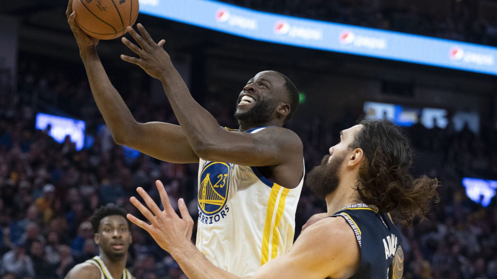 Golden State Warriors forward Draymond Green, left, goes up for a basket with right hand against Memphis Grizzlies center Steven Adams, right, on May 9, 2022, in San Francisco.