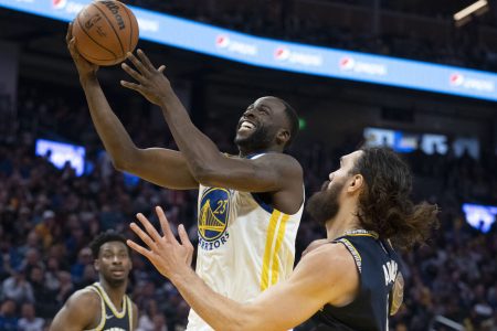Golden State Warriors forward Draymond Green, left, goes up for a basket with right hand against Memphis Grizzlies center Steven Adams, right, on May 9, 2022, in San Francisco.