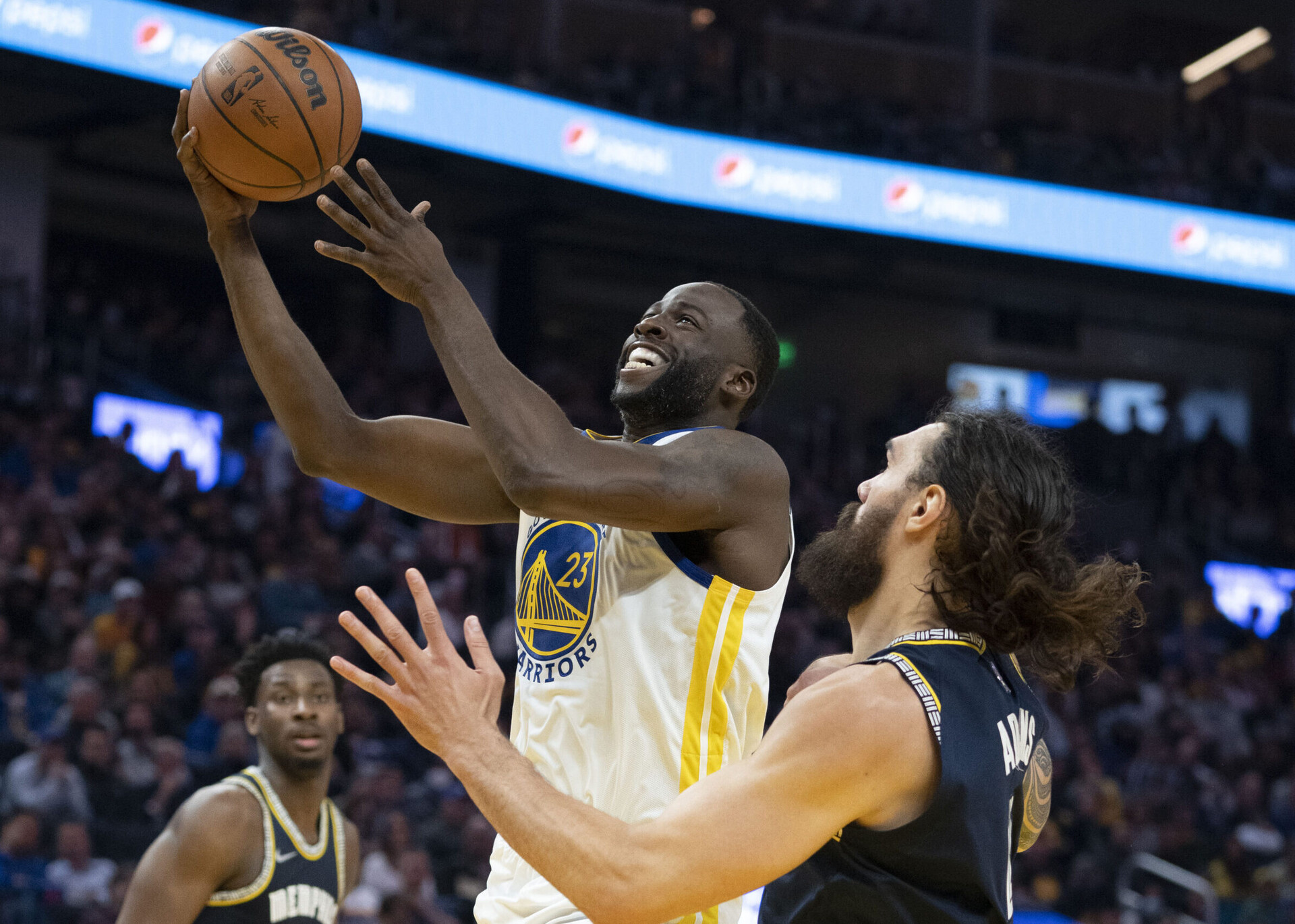 Golden State Warriors forward Draymond Green, left, goes up for a basket with right hand against Memphis Grizzlies center Steven Adams, right, on May 9, 2022, in San Francisco.