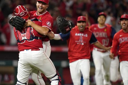 Los Angeles Angels starting pitcher Reid Detmers is lifted in the air by catcher Chad Wallach after throwing a no hitter against the Tampa Bay Rays