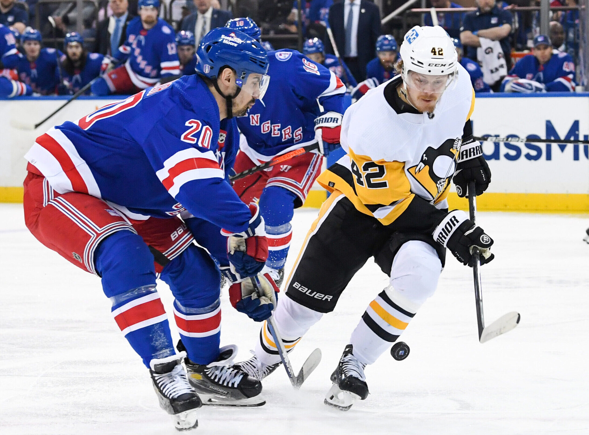 Pittsburgh Penguins right wing Kasperi Kapanen (right) and New York Rangers left wing Chris Kreider (left) battle for a loose puck during a 2022 Stanley Cup Playoffs game