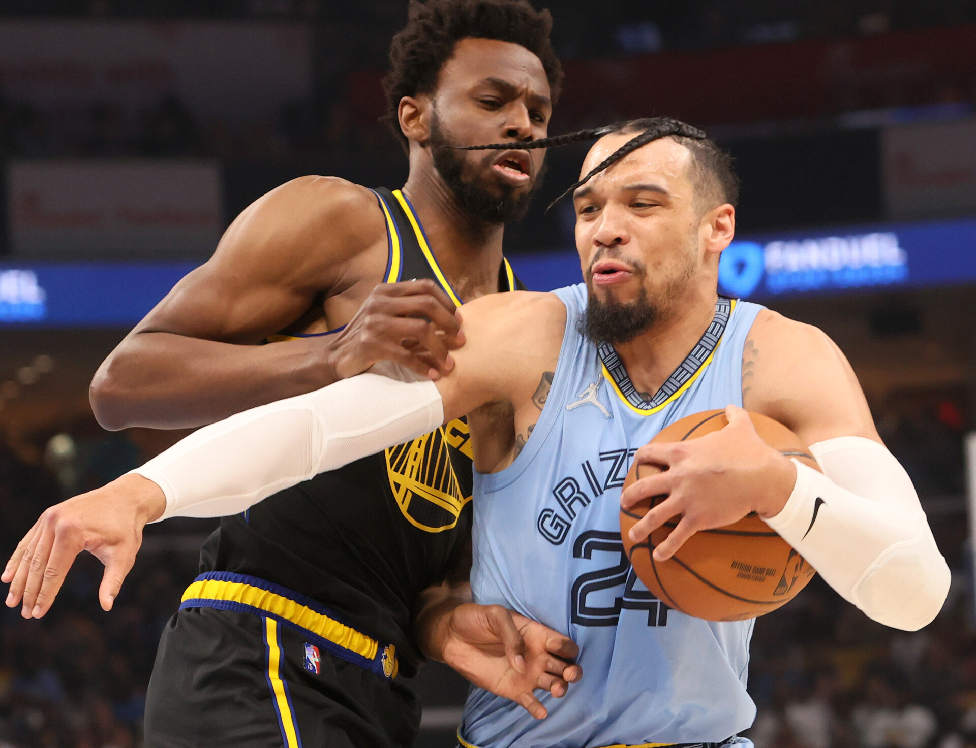 Memphis Grizzlies guard Dillon Brooks, right, drives with the ball cradled in his left hand and hair whipping across his forehead as Golden Warriors forward Andrew Wiggins defends on Wednesday, May 11, 2022, in Memphis, Tenn.