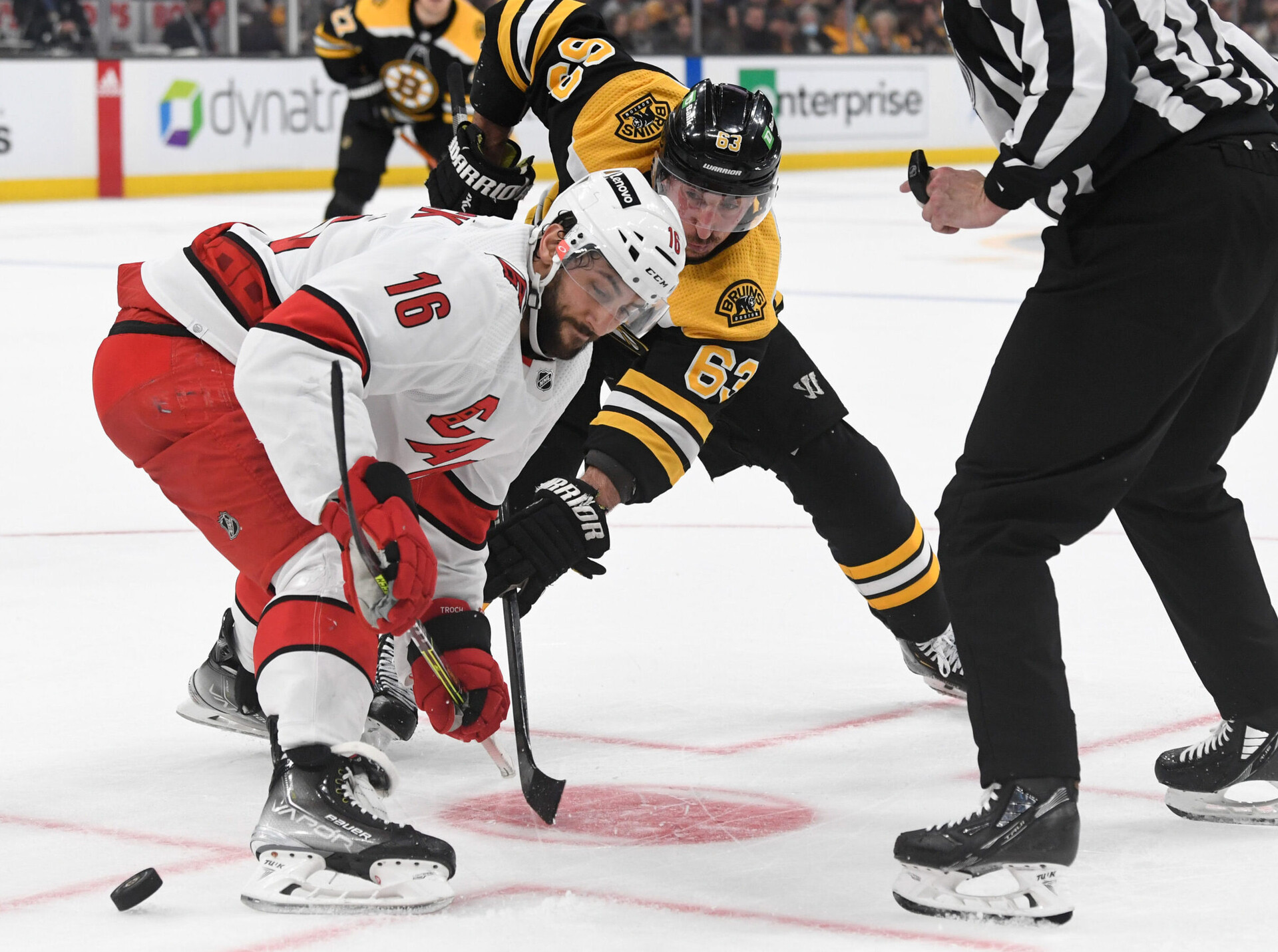 Boston Bruins left wing Brad Marchand (right) and Carolina Hurricanes center Vincent Trocheck (left) eye a rolling puck after a face-off during a 2022 Stanley Cup Playoffs game