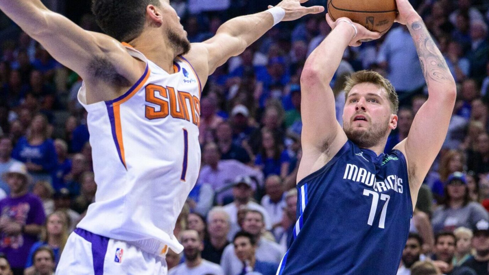 Dallas Mavericks guard Luka Doncic, right, shoots over Phoenix Suns guard Devin Booker, left, during the third quarter during game six of the second round of the 2022 NBA playoffs at the American Airlines Center on May 12, 2022.