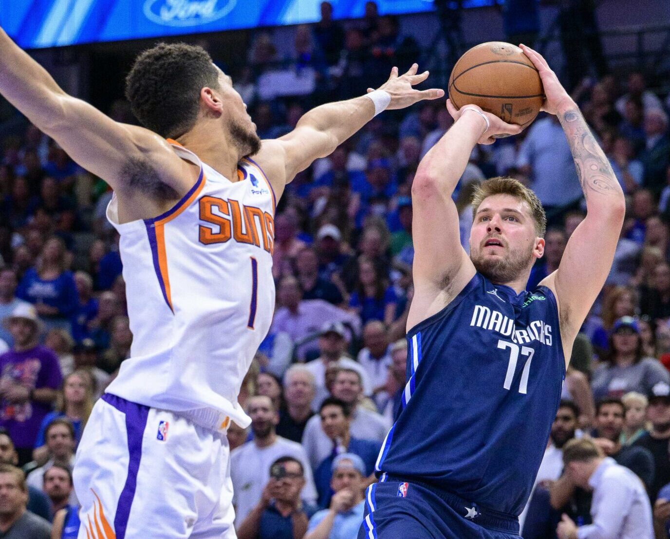 Dallas Mavericks guard Luka Doncic, right, shoots over Phoenix Suns guard Devin Booker, left, during the third quarter during game six of the second round of the 2022 NBA playoffs at the American Airlines Center on May 12, 2022.