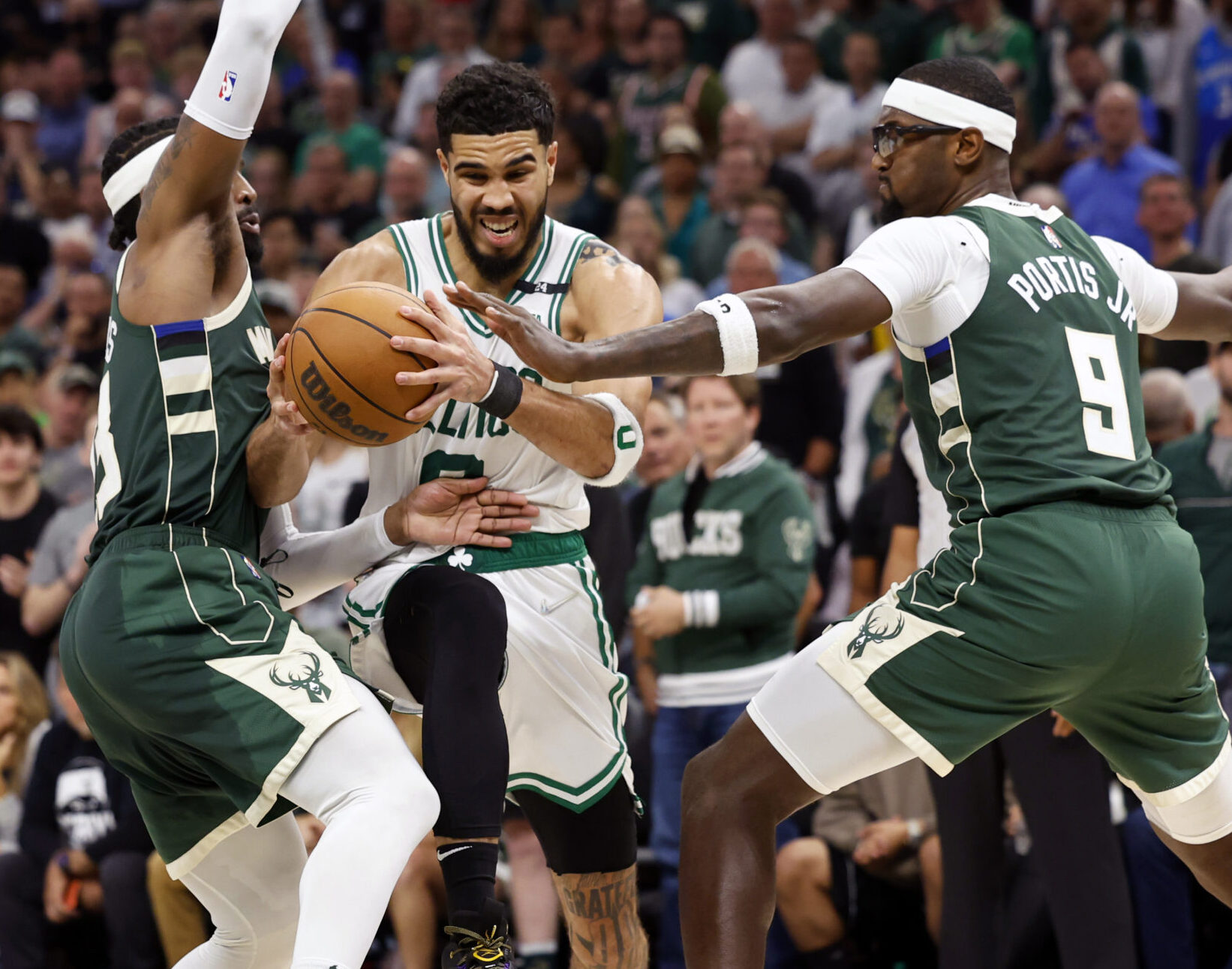 Boston Celtics forward Jayson Tatum, middle, drives for the basket between Milwaukee Bucks guard Wesley Matthews, left, and forward Bobby Portis, right, during the fourth quarter during game six of the second round for the 2022 NBA playoffs at Fiserv Forum on May 13, 2022.