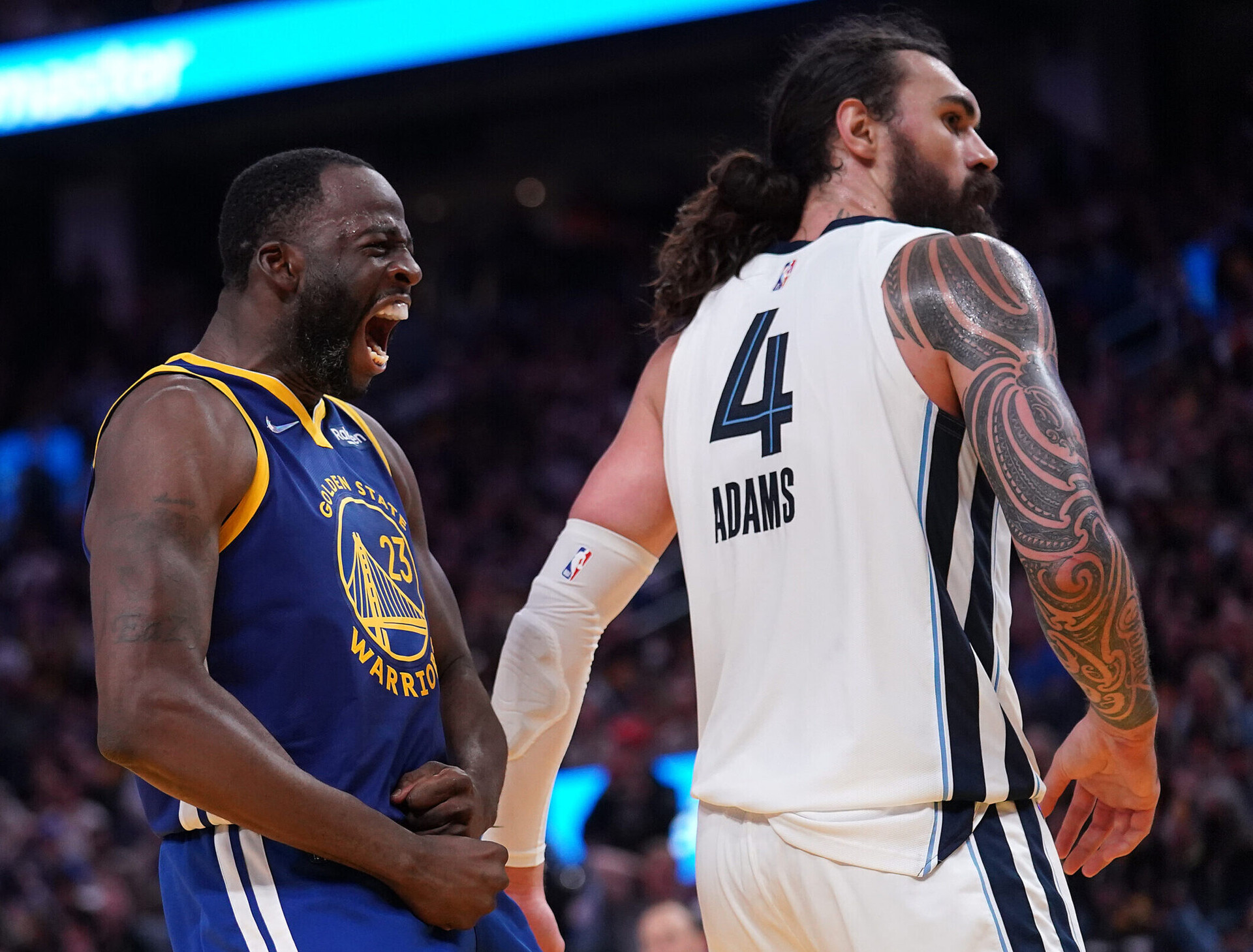 Golden State Warriors forward Draymond Green, left, yells in front of Memphis Grizzlies center Steven Adams, looking away at right, after making a basket on May 13, 2022, in San Francisco.