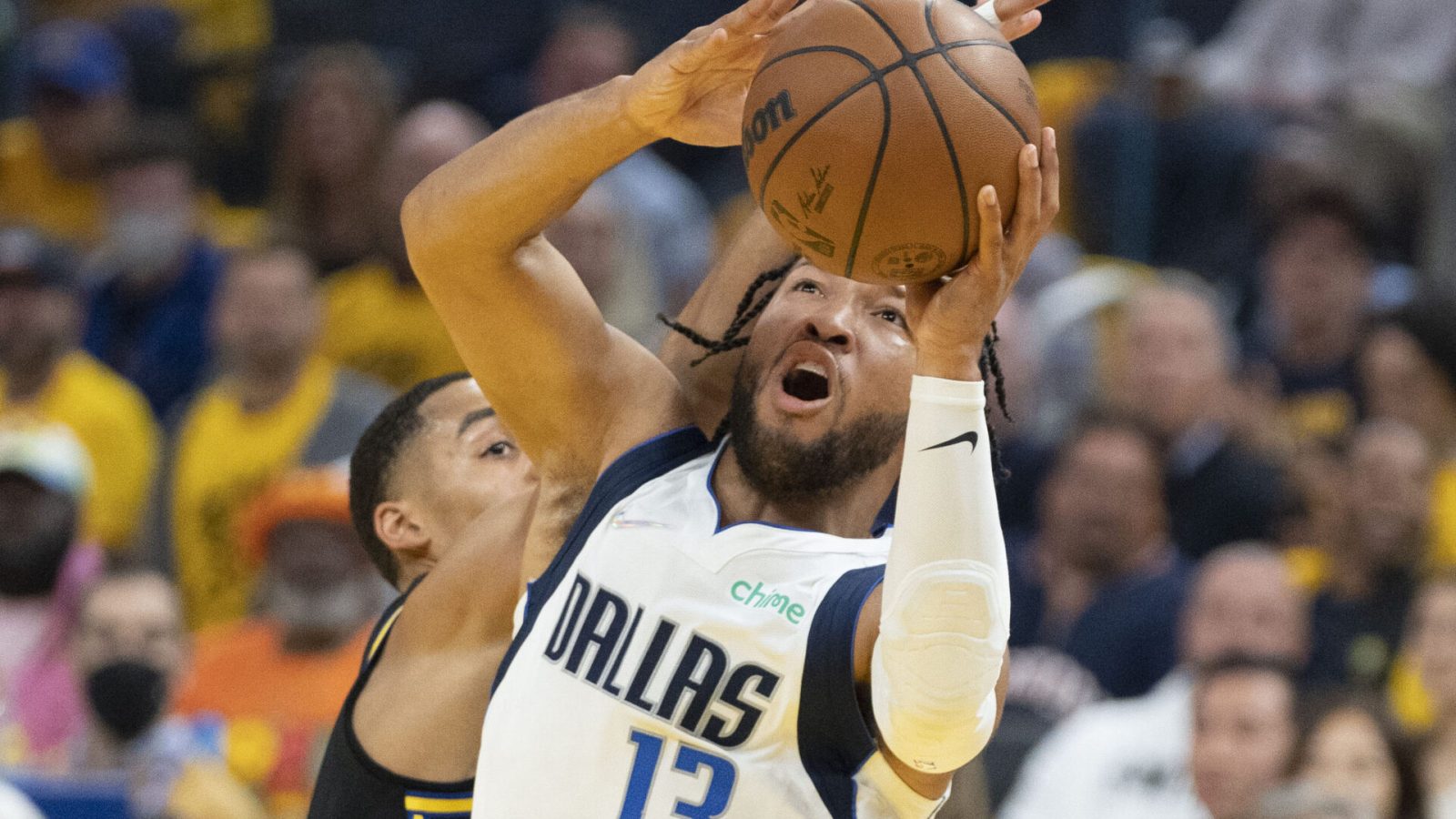 Dallas Mavericks guard Jalen Brunson, right, goes up for a shot with both hands as he moves past Golden State Warriors guard Jordan Poole, left, on Wednesday, May 18, 2022, in San Francisco.