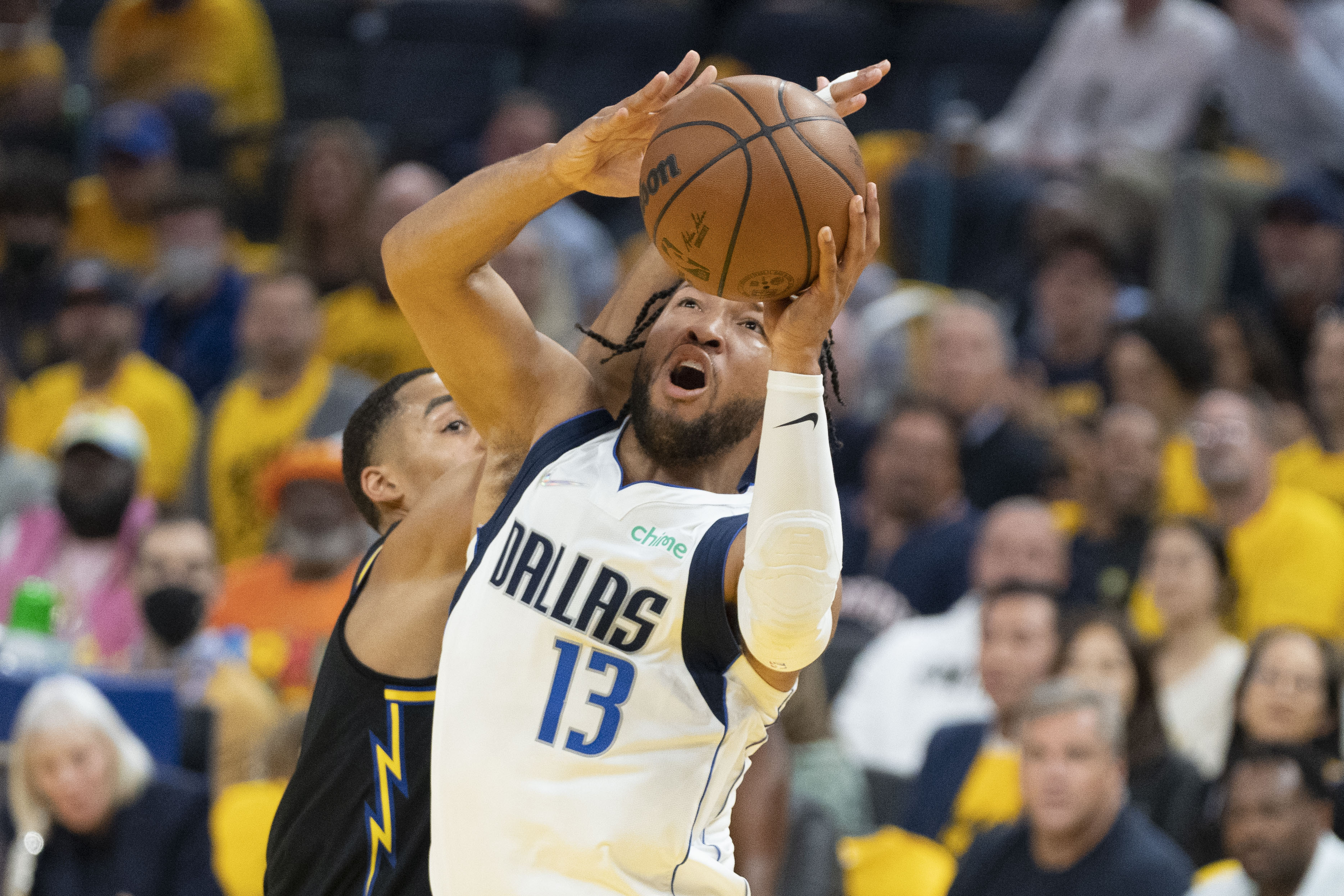 Dallas Mavericks guard Jalen Brunson, right, goes up for a shot with both hands as he moves past Golden State Warriors guard Jordan Poole, left, on Wednesday, May 18, 2022, in San Francisco.