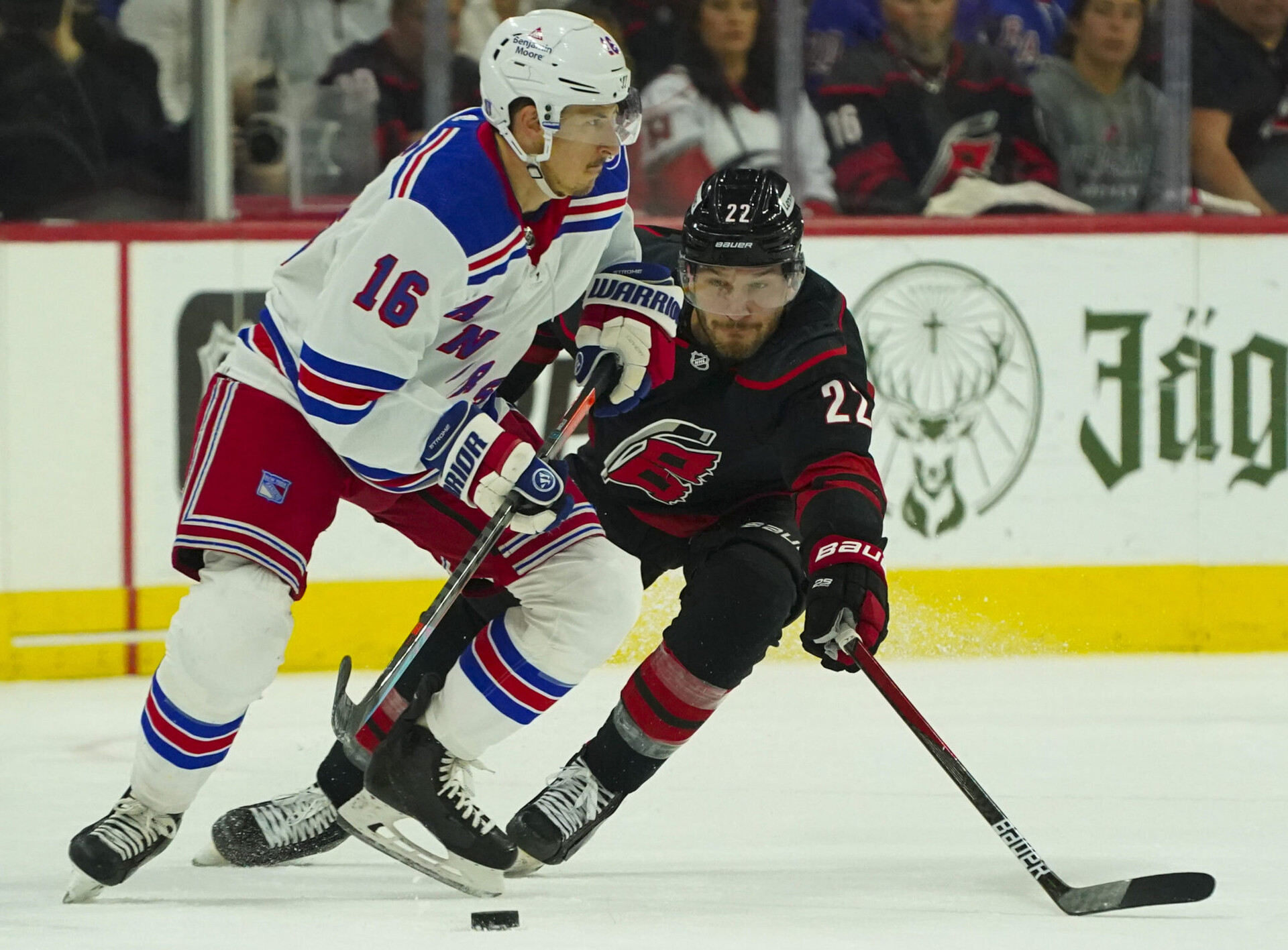 New York Rangers center Ryan Strome (left) tries to control the puck while Carolina Hurricanes defenseman Brett Pesce (right) applies pressure during Game 2 of the second round of the 2022 Stanley Cup Playoffs