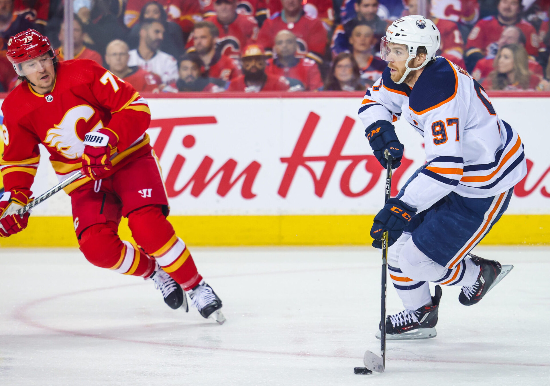 Edmonton Oilers center Connor McDavid (right) skates with the puck while Calgary Flames right wing Tyler Toffoli (right) pursues during Game 2 of the second round of the 2022 Stanley Cup Playoffs