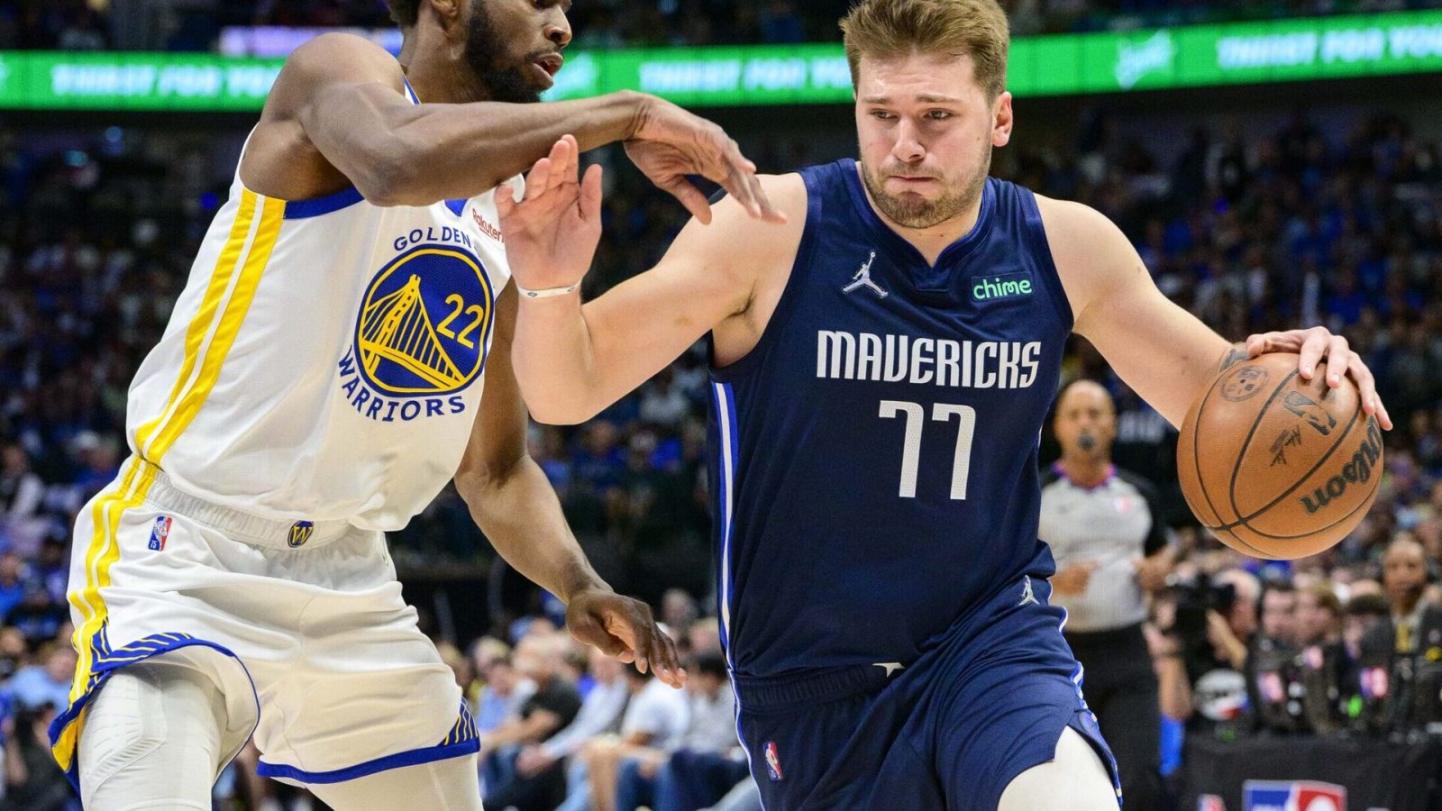 Dallas Mavericks guard Luka Doncic (right) dribbles the basketball with his left hand as he tries to get around Golden State Warriors defender Andrew Wiggins (left) during Game 3 of the NBA Western Conference Finals