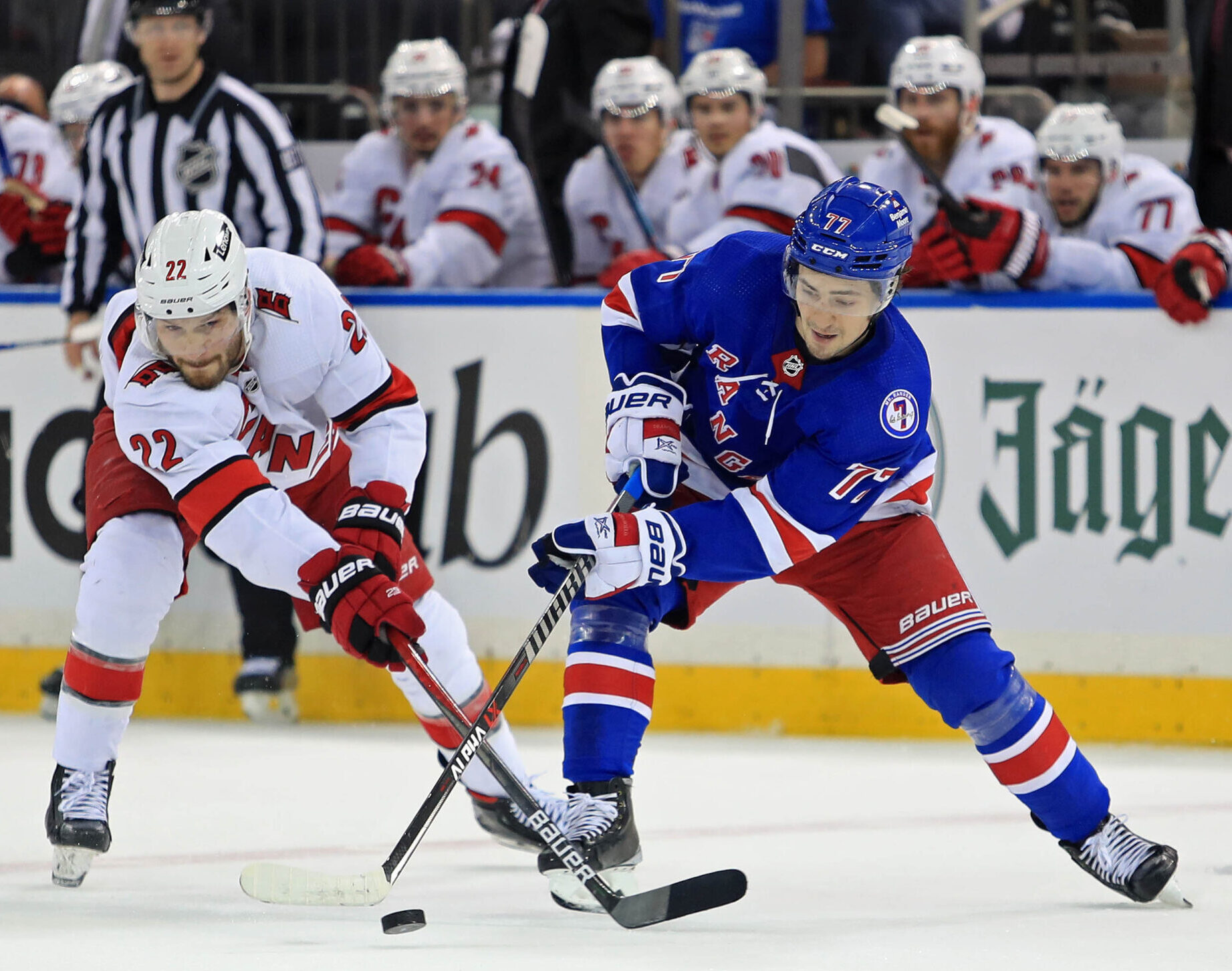 Carolina Hurricanes defenseman Brett Pesce (left) and New York Rangers center Frank Vatrano (right) fight for the puck during Game 4 of the second round of the 2022 Stanley Cup Playoffs