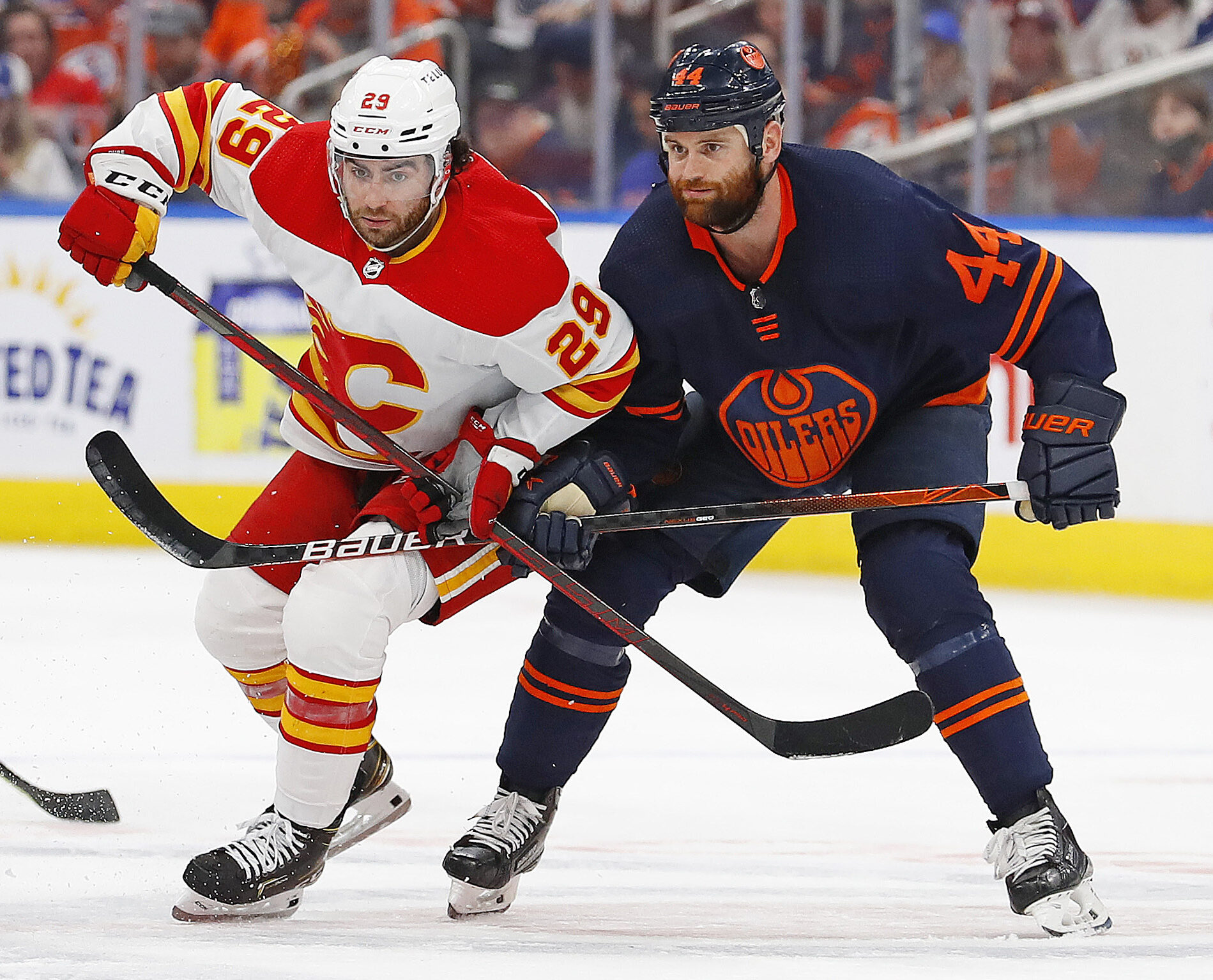 Edmonton Oilers forward Zack Kassian (left) and Calgary Flames forward Dillon Dube (right) look for a loose puck during Game 4 of the second round of the 2022 Stanley Cup Playoffs