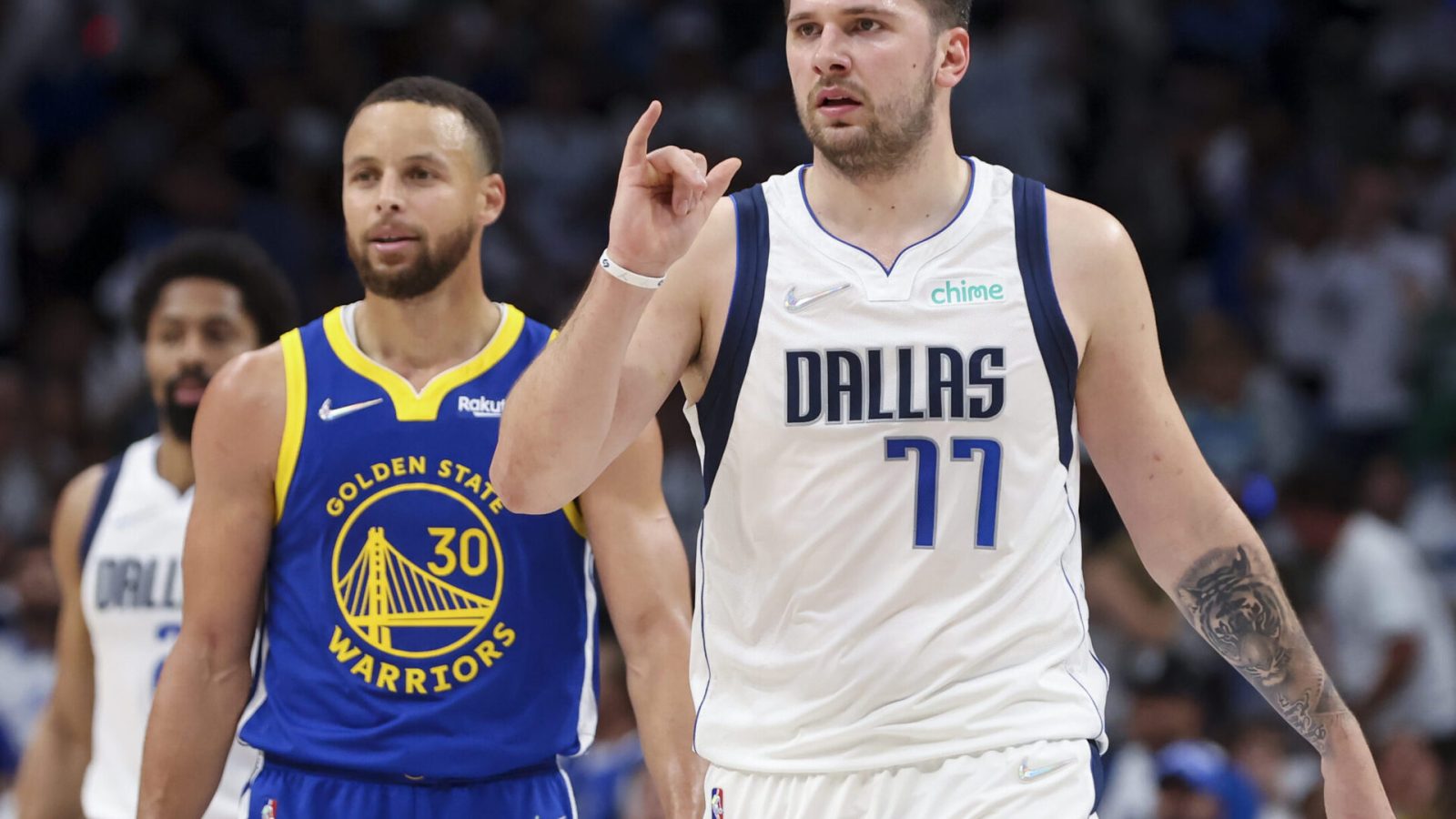 Dallas Mavericks guard Luka Doncic, right, and Golden State Warriors guard Stephen Curry, left, look to the sidelines during a break in play Tuesday, May 24, 2022, in Dallas.
